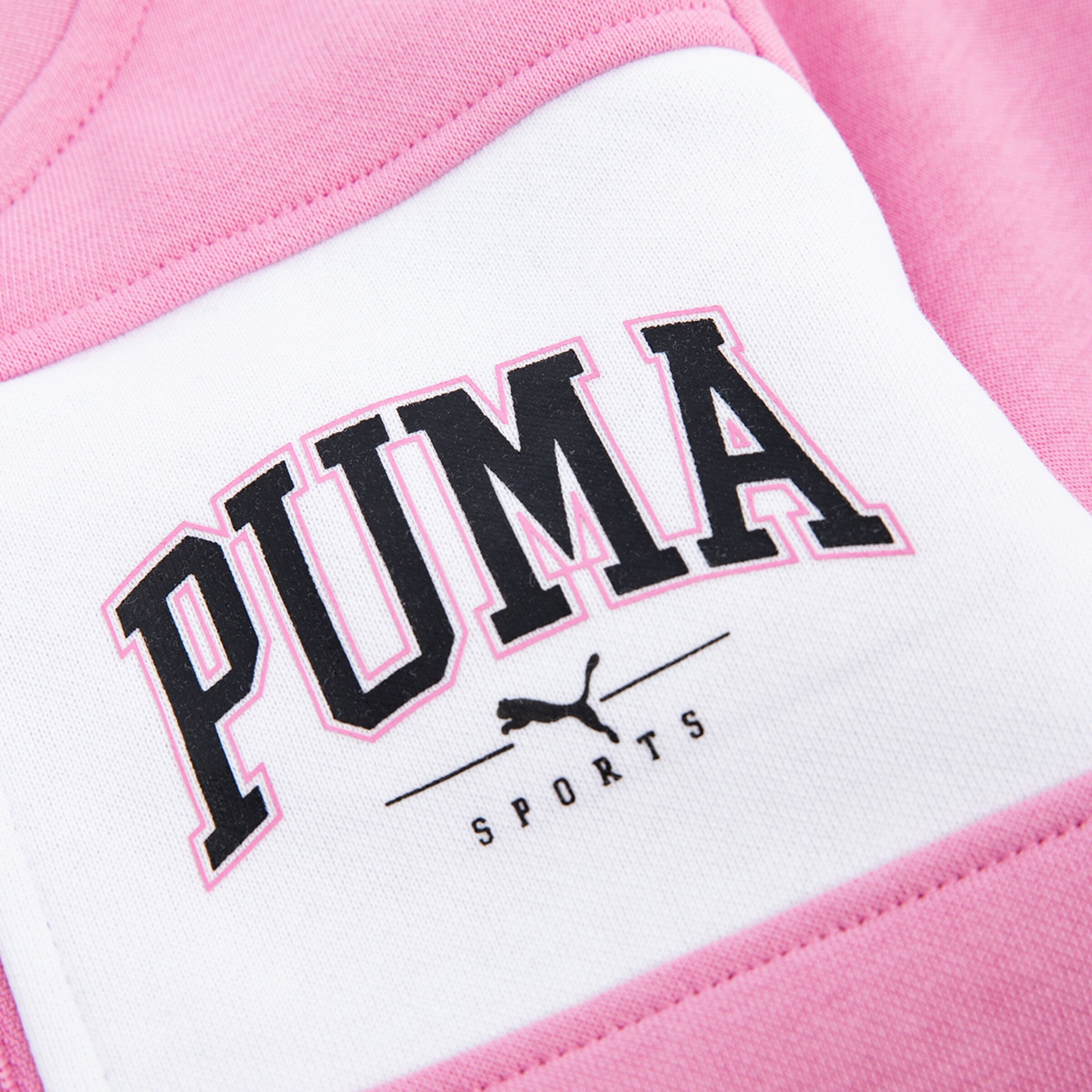Puma logo on a pink sweatshirt featuring the text PUMA SPORTS in black.