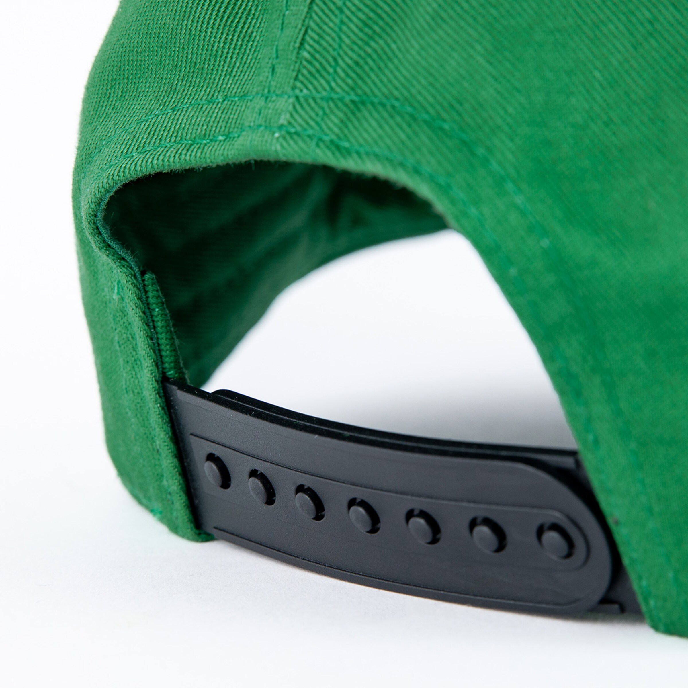 Close-up of a green baseball cap with an adjustable black strap.