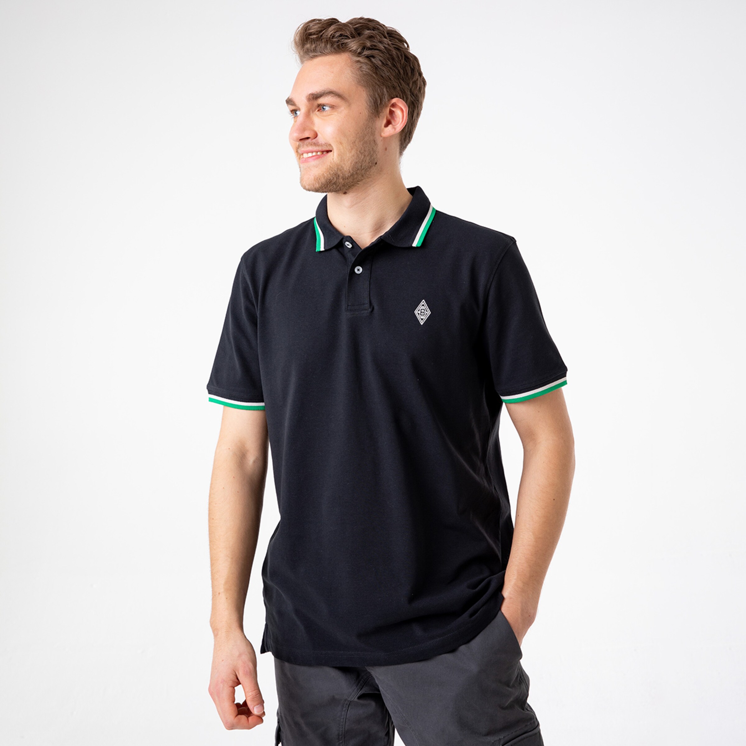 Man wearing a black polo shirt with green accents and logo.