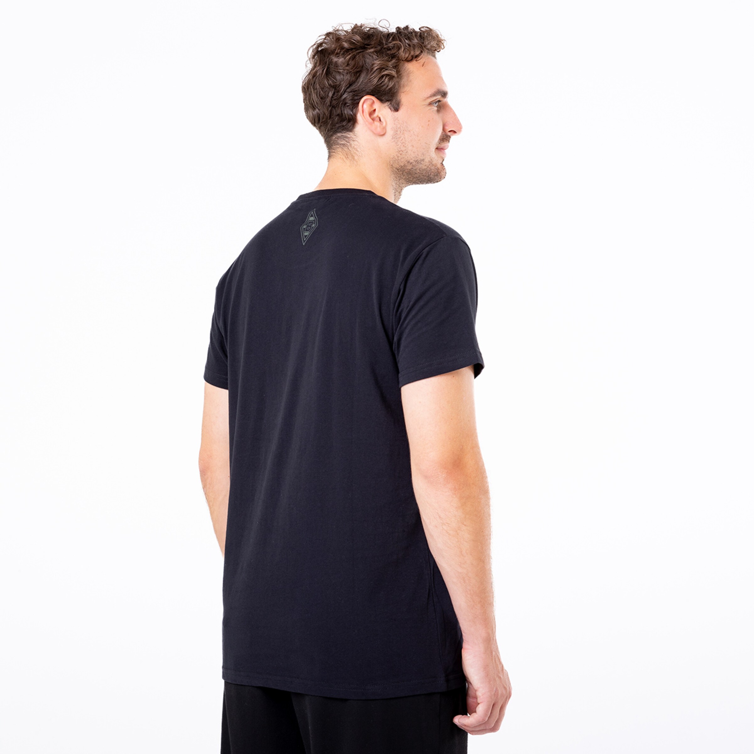 Mann in schwarzem T-Shirt von hinten mit kurzem lockigem Haar.