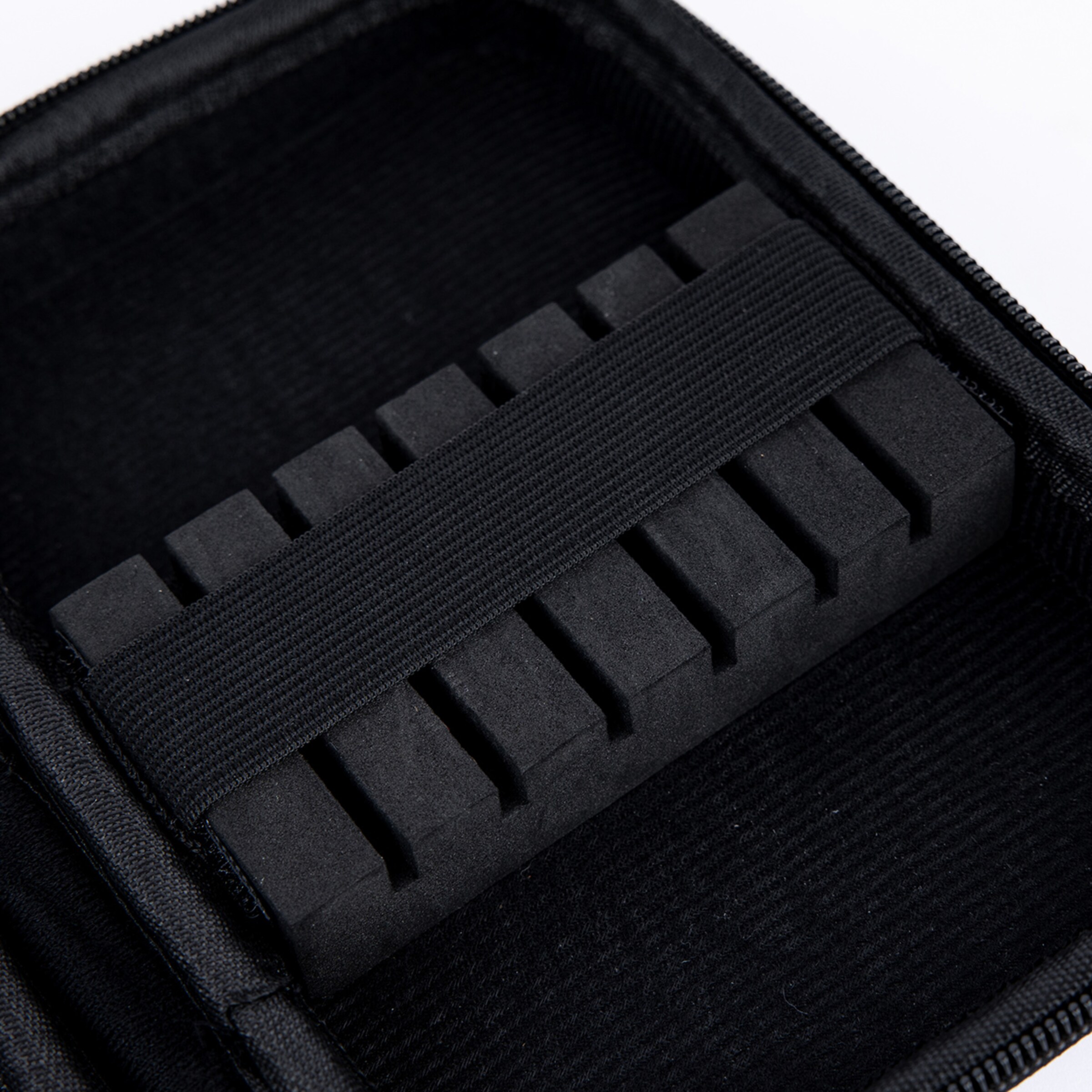 Innenansicht einer schwarzen Tasche mit Schaumstoff-Organizer, Schlitzen und elastischem Band zur Fixierung von Kleinteilen.