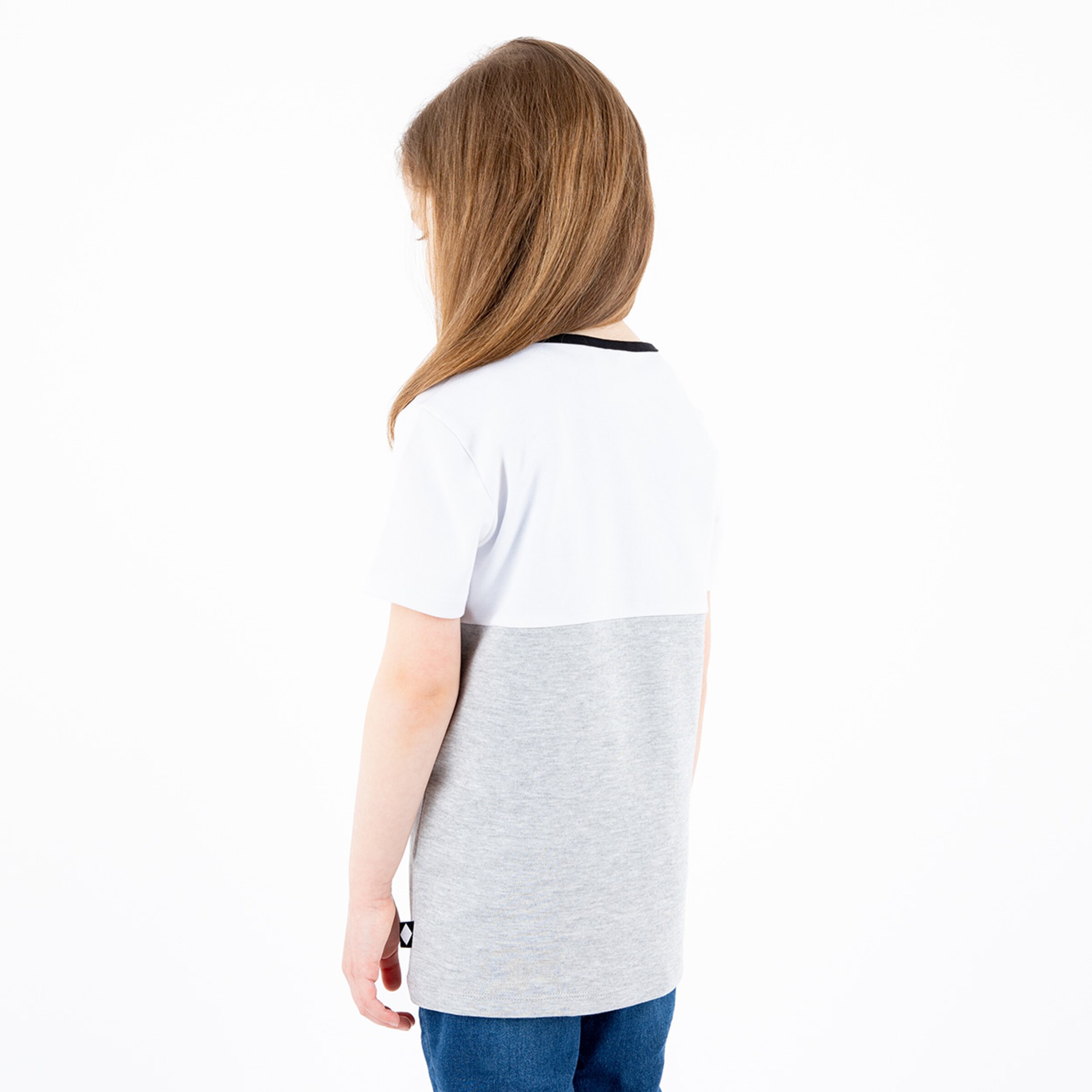 Rückansicht eines Mädchens mit langen Haaren in einem grauen und weißen T-Shirt.