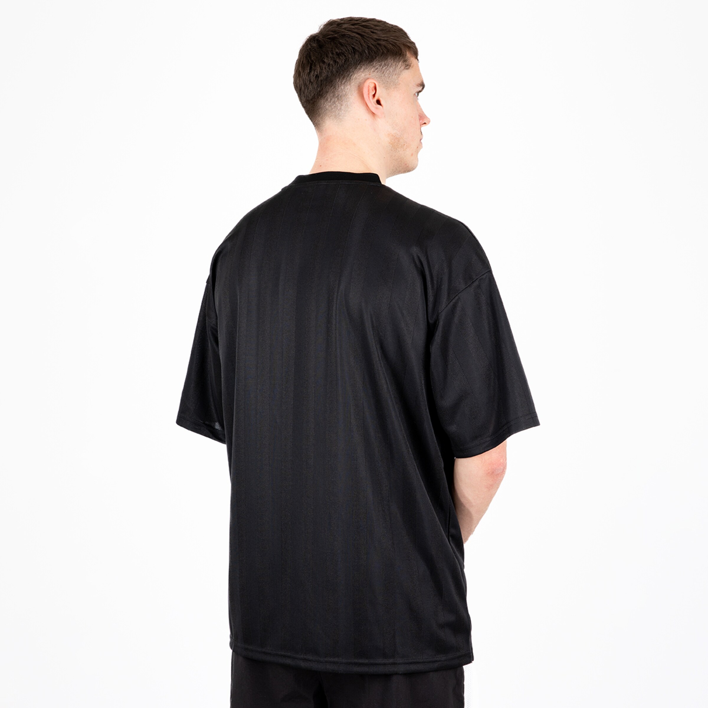 Schwarzes Sportshirt aus weichem Material Rückansicht eines jungen Mannes.