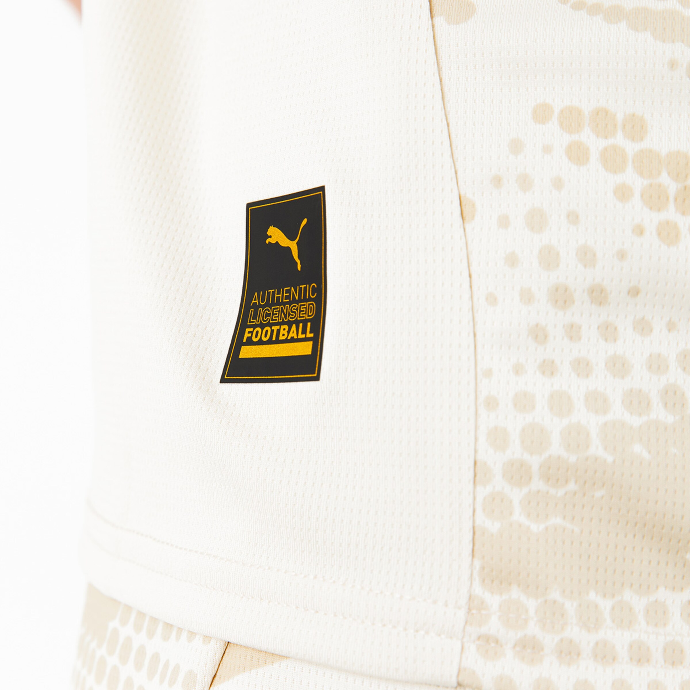 Puma-Logo auf einem Fußballtrikot in hellen Farben mit dem Text AUTHENTIC LICENSED FOOTBALL.