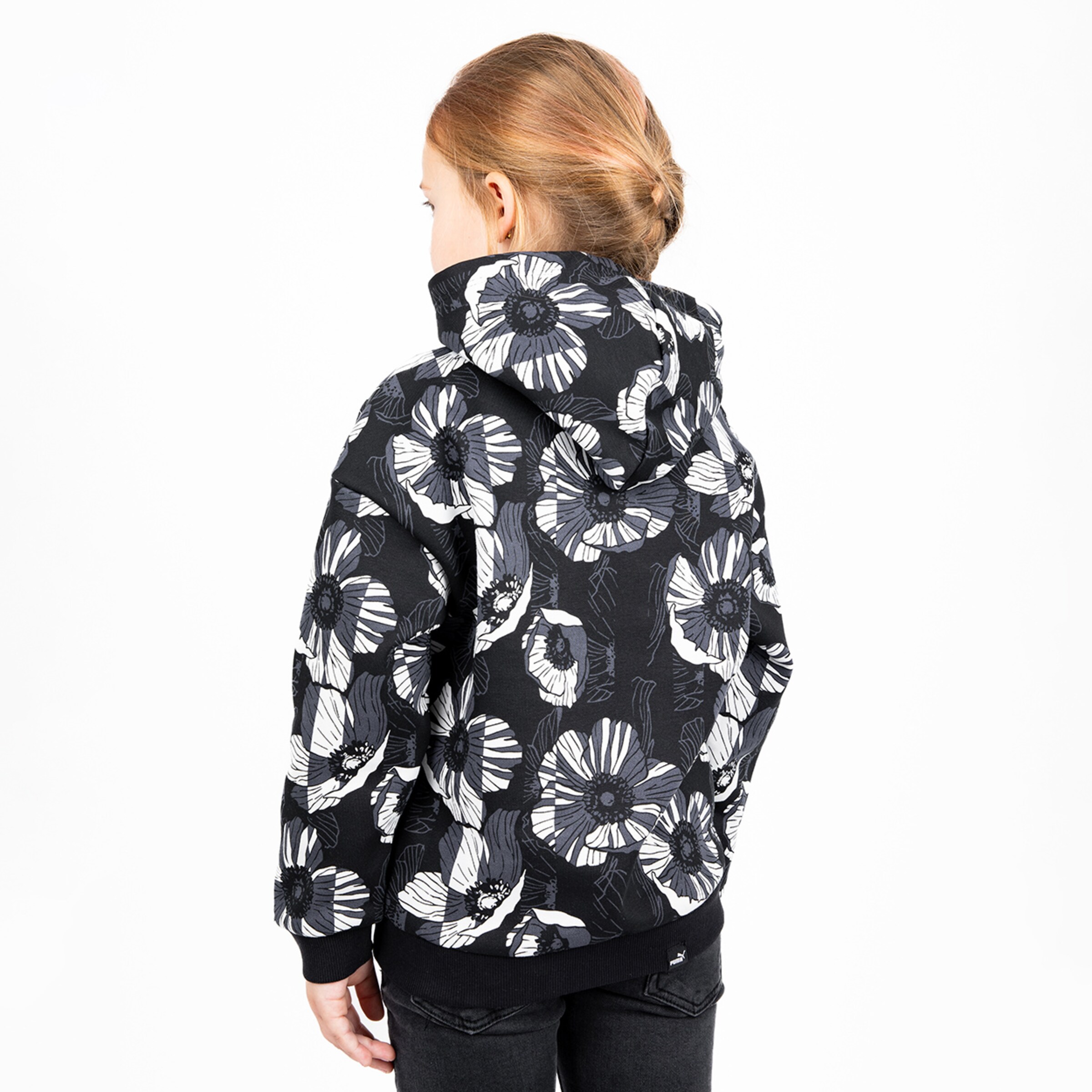 Girl from behind wearing a black jacket with floral pattern.