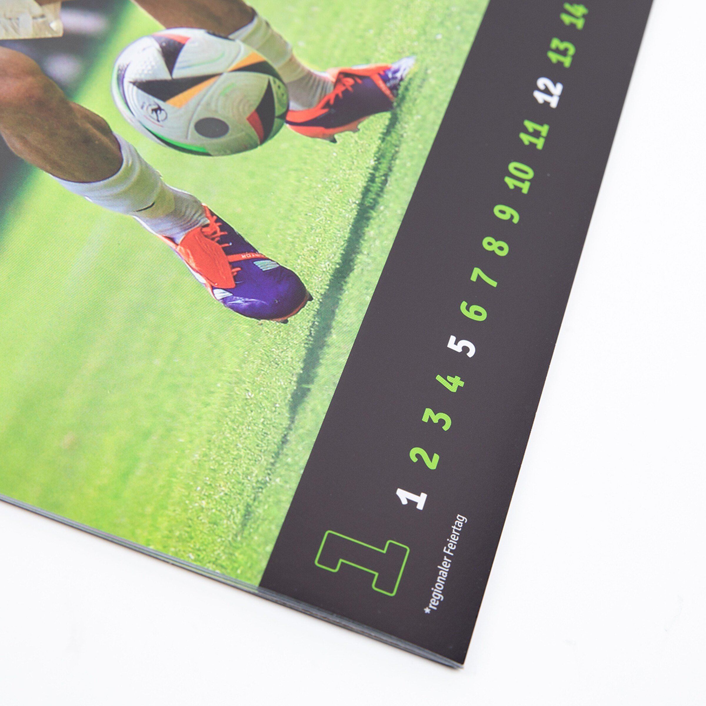 Ausschnitt eines Kalenders mit einem Fußballspiel und Zahlen.