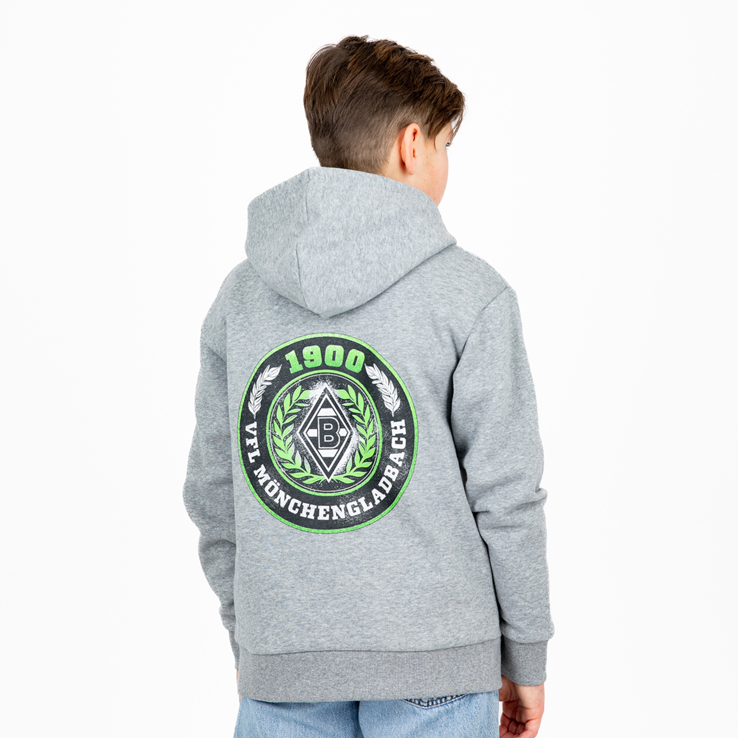 Junge trägt grauen Kapuzenpullover mit aufgedrucktem Wappen von Borussia Mönchengladbach auf dem Rücken.