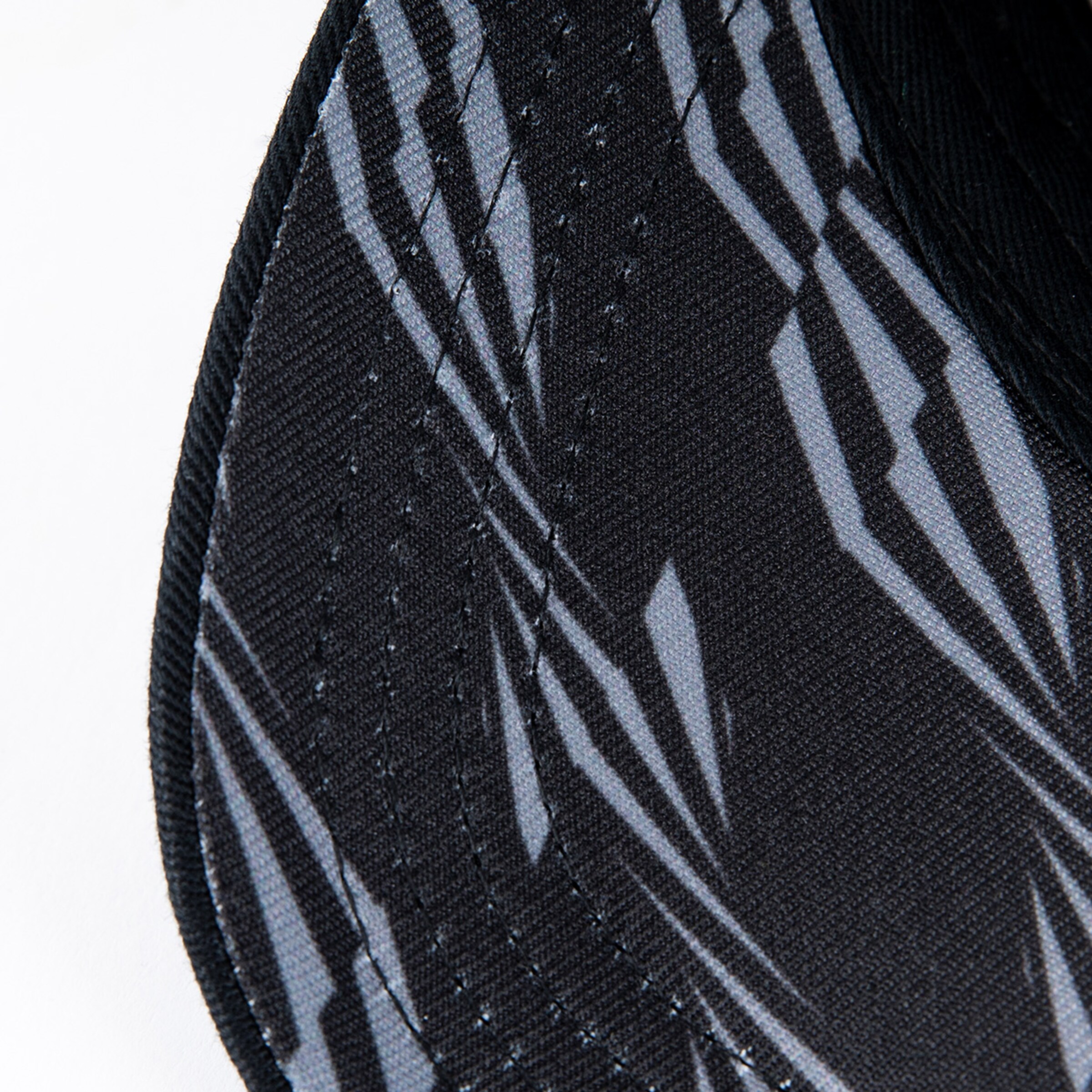 Close-up view of a black cap with a graphic pattern.