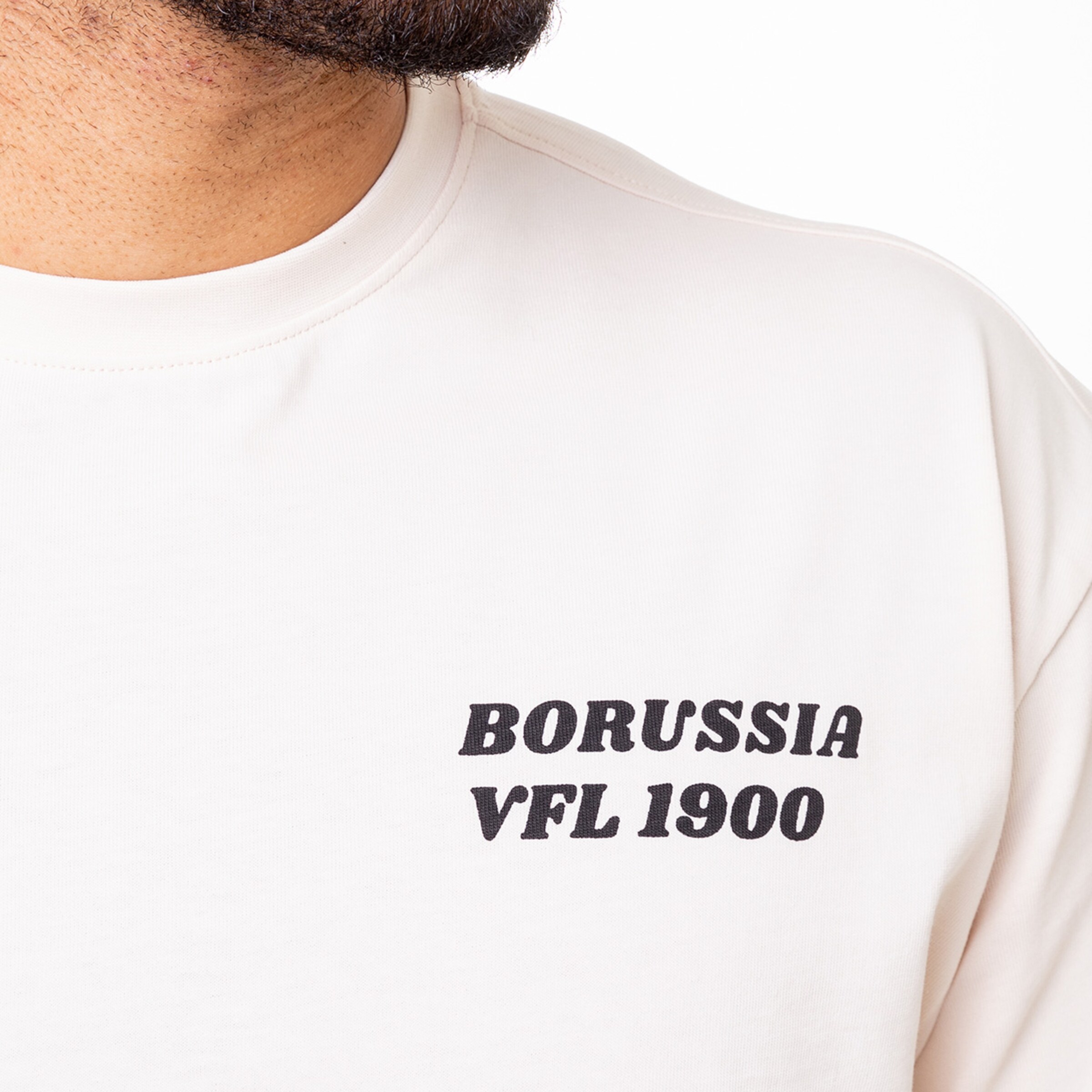 Man wearing a t-shirt featuring Borussia VFL 1900 print.