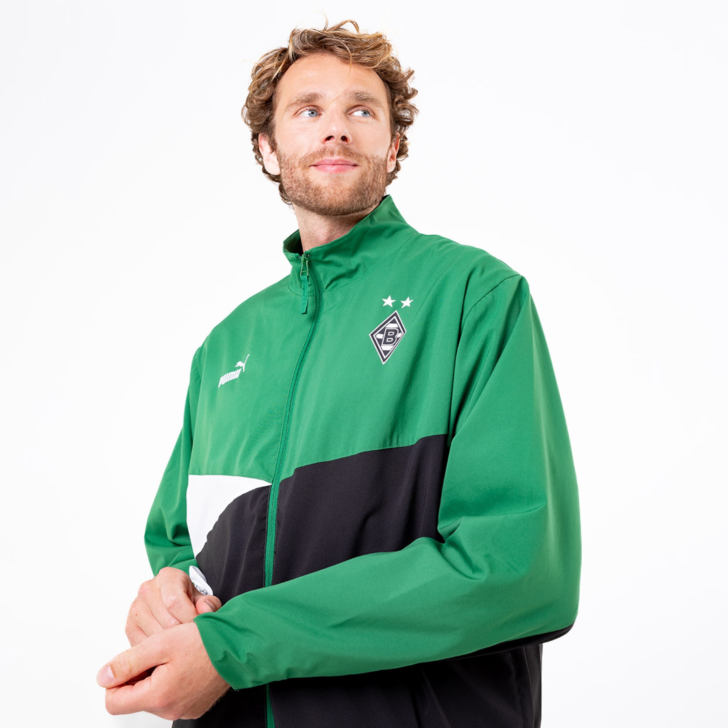 Mann trägt grüne Jacke mit schwarzer Unterseite und Borussia Mönchengladbach-Logo.