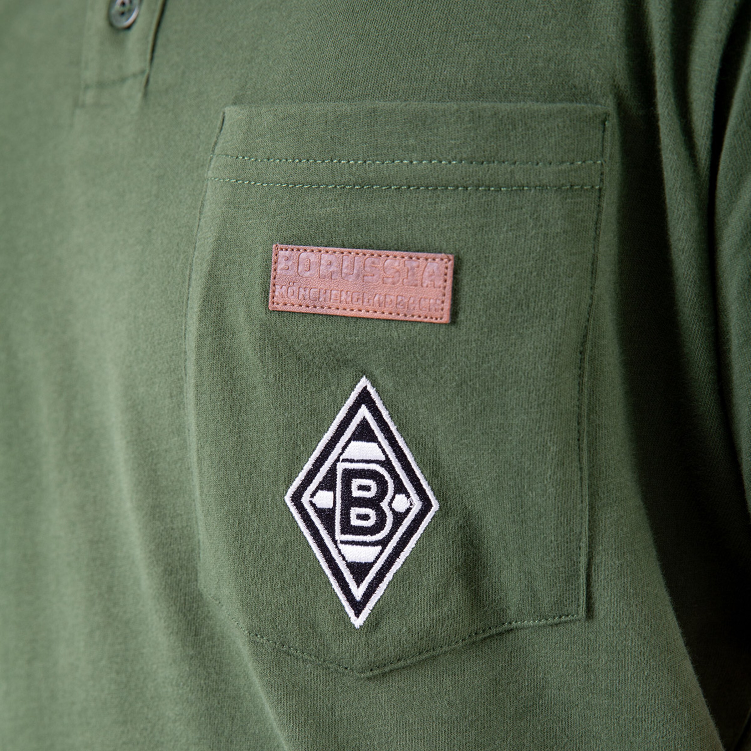 Green polo shirt with embroidered Borussia Mönchengladbach logo and a label patch.