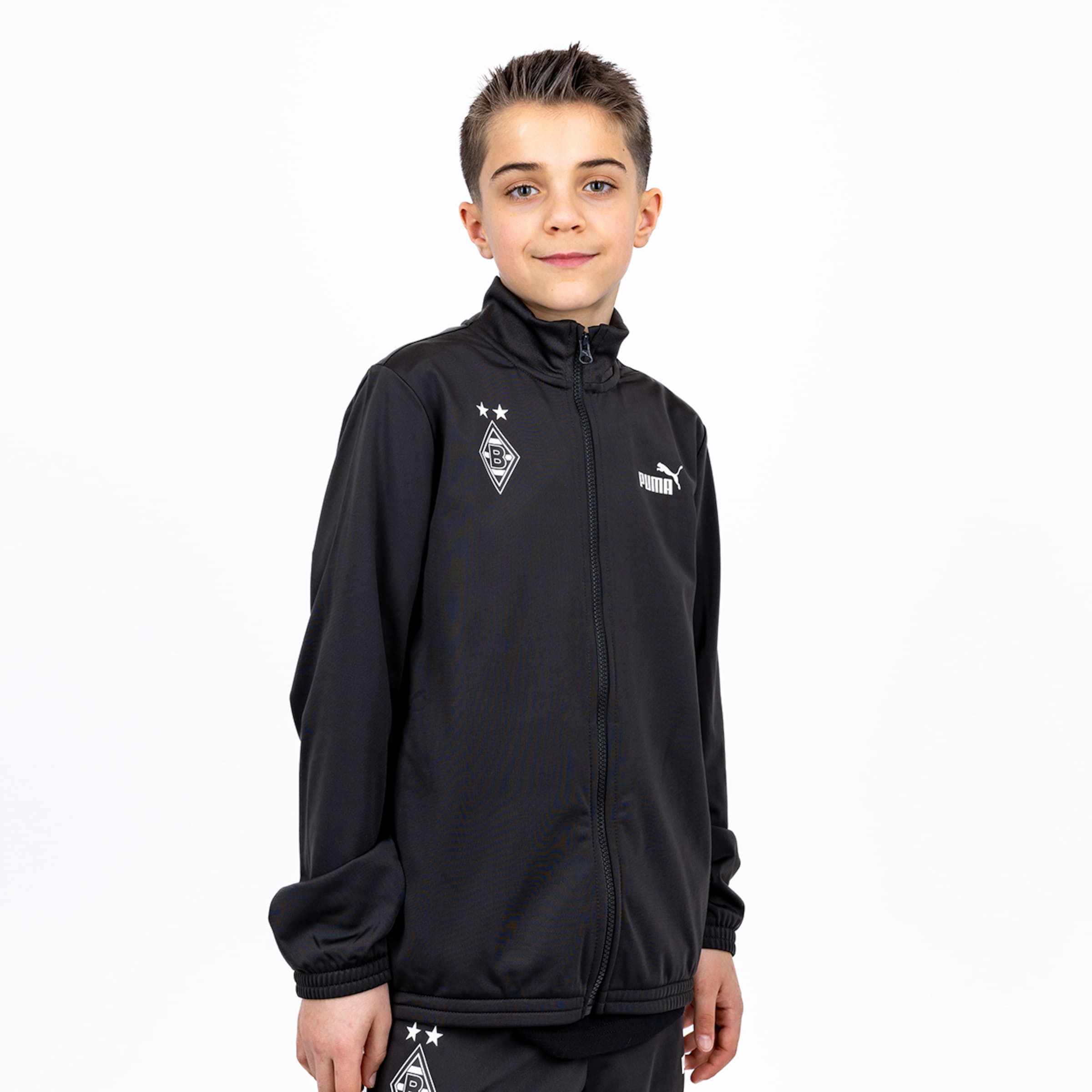 A boy wearing a black Puma track jacket with the Borussia Mönchengladbach club logo on a plain white background.