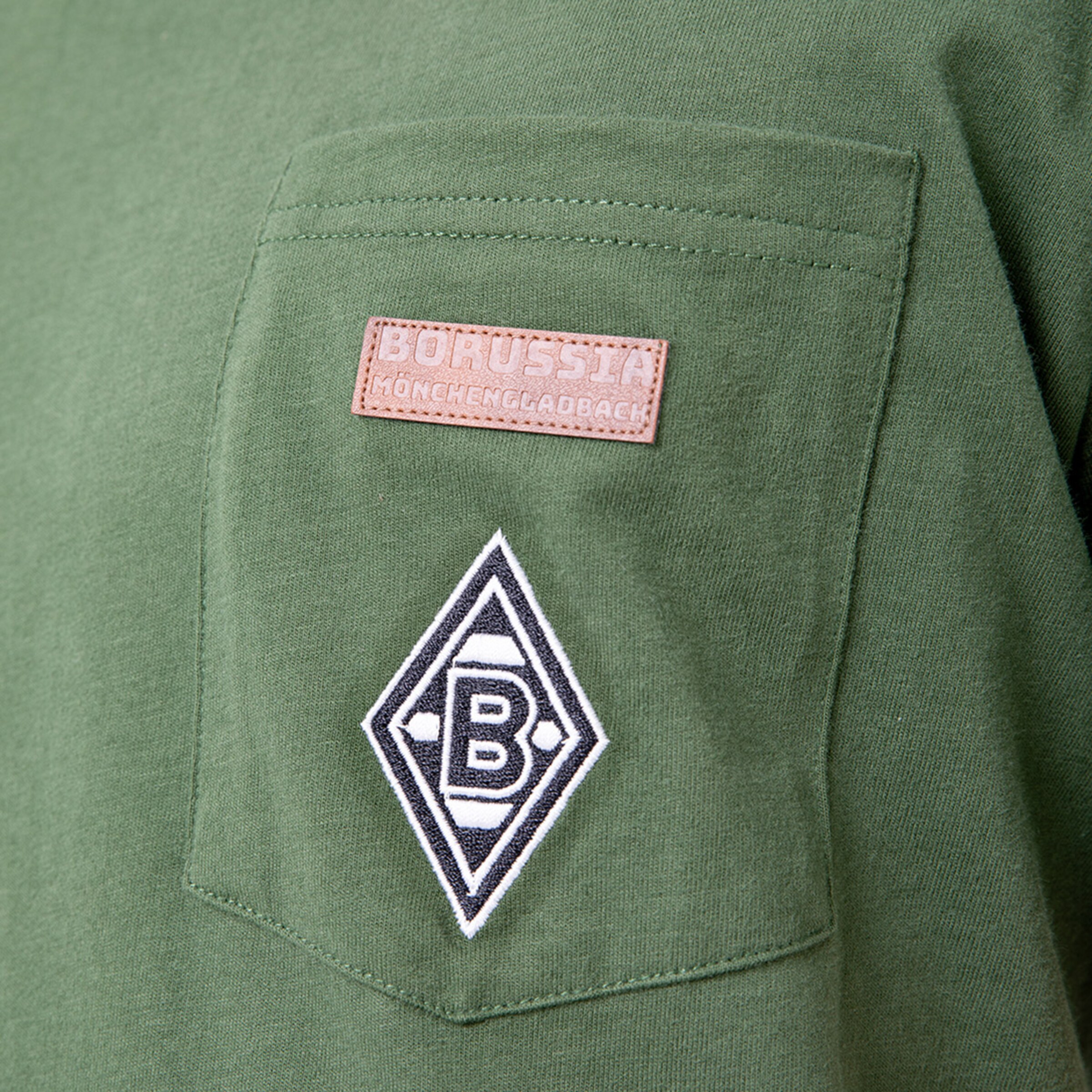Grünes T-Shirt mit Brusttasche; Aufnäher mit Borussia Mönchengladbach und Vereinslogo.