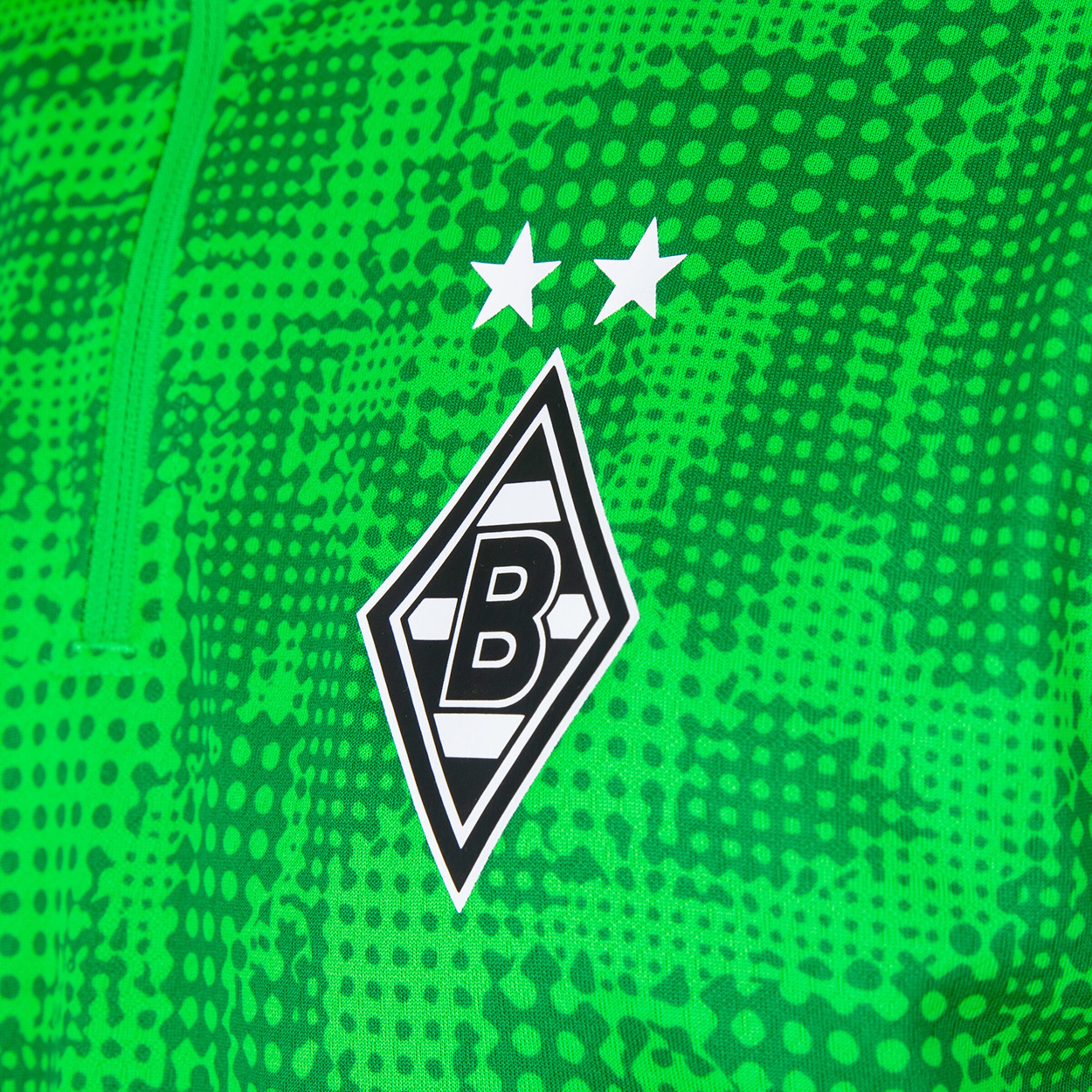 Logo von Borussia Mönchengladbach auf einem Trikot in Grün mit zwei Sternen darüber.