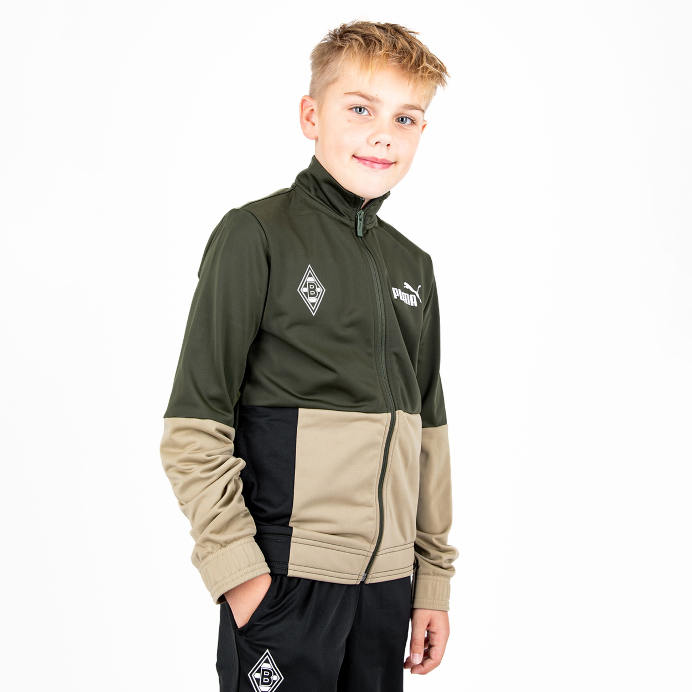 Junge trägt eine grüne und beige Jacke von Puma mit Borussia Mönchengladbach-Logo.