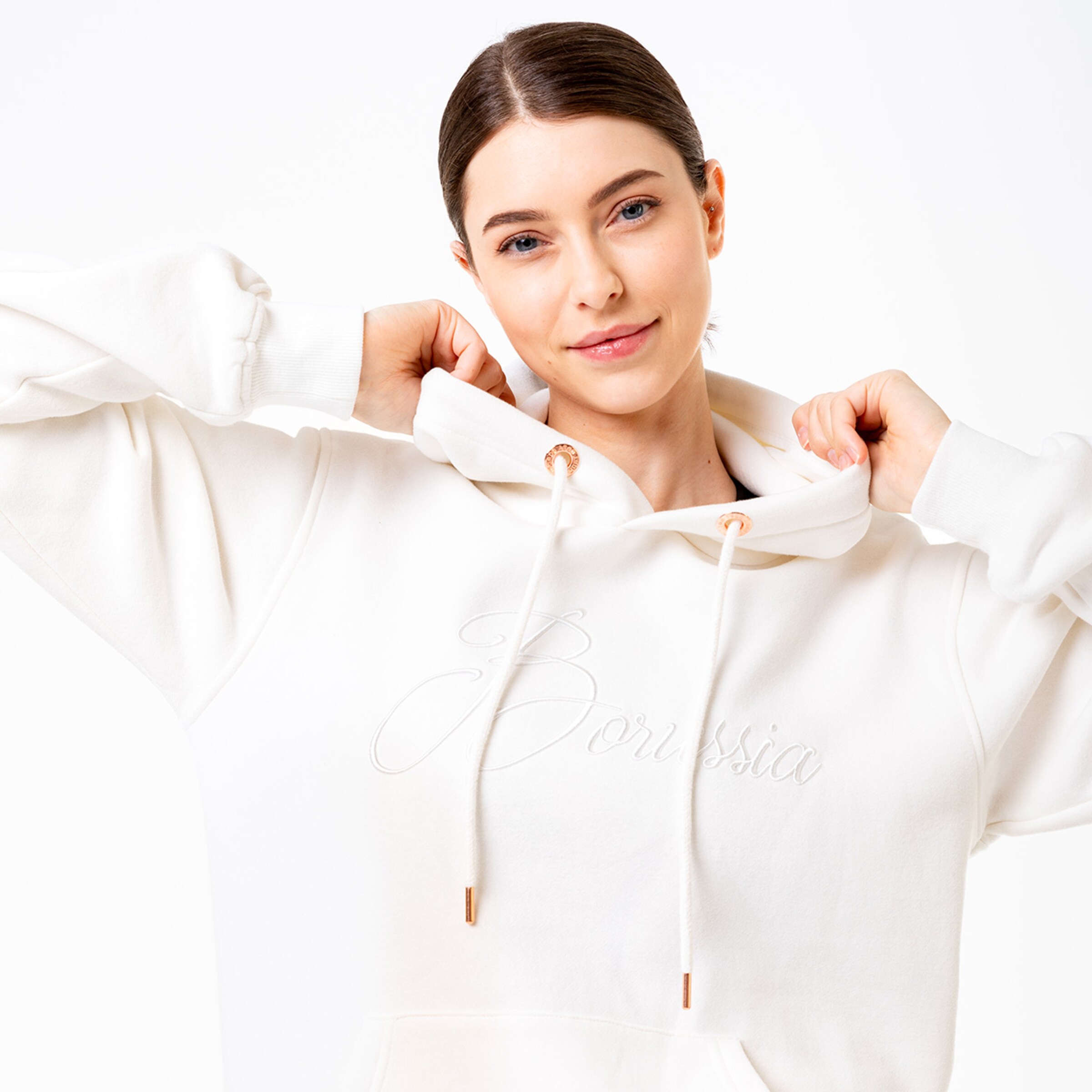 Frau trägt einen weißen Hoodie mit Borussia-Schriftzug.