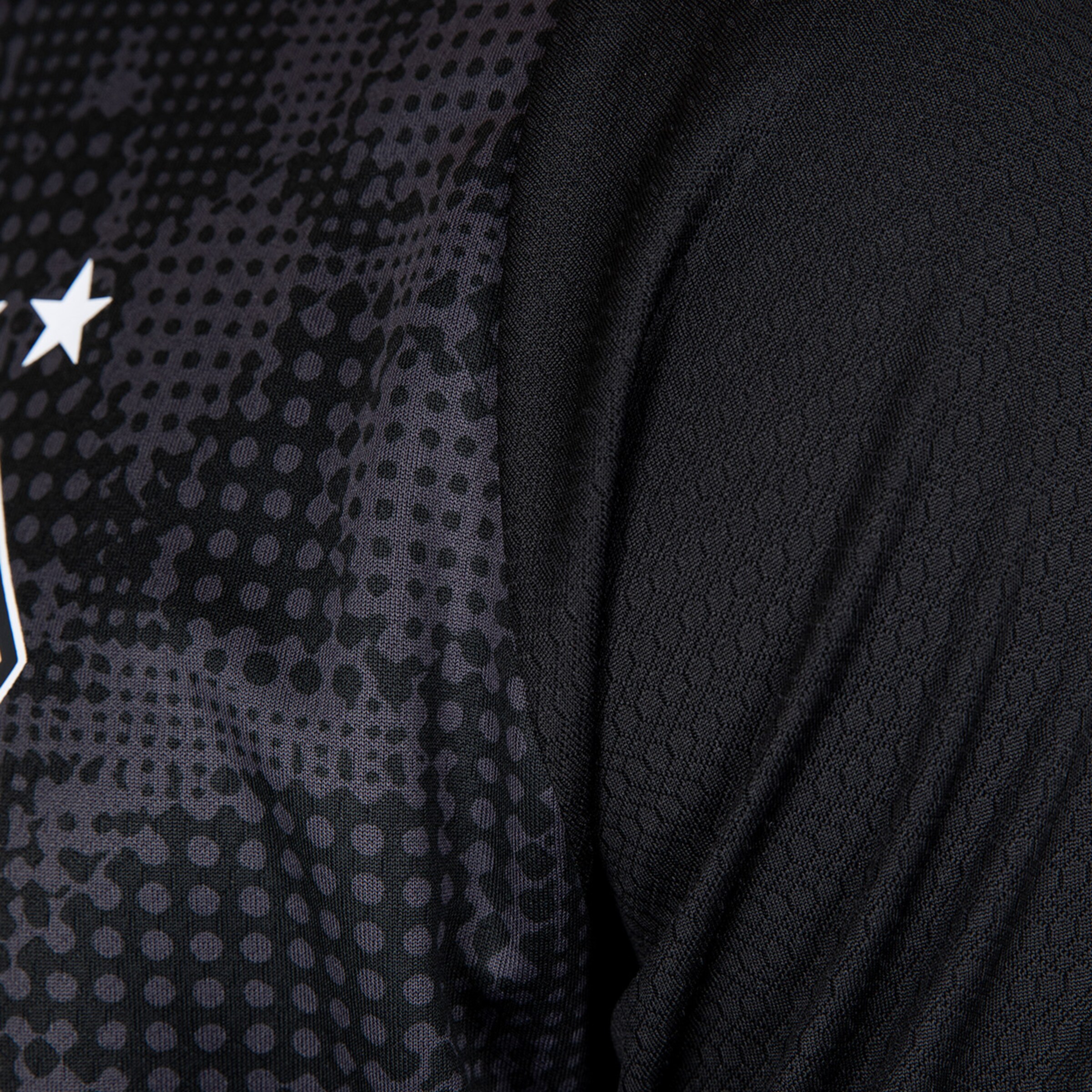 Nahaufnahme von einem schwarzen Fußballtrikot mit strukturiertem Muster.