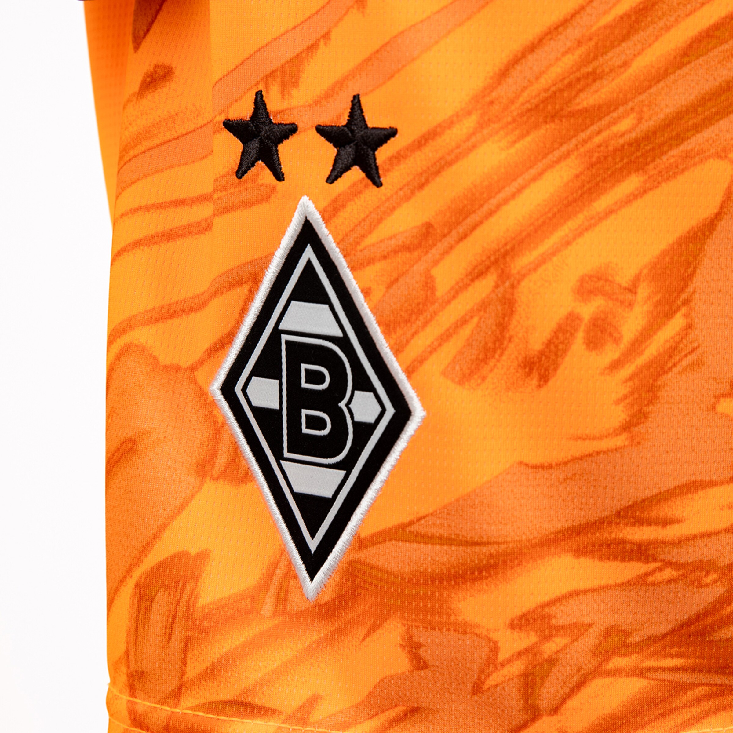 Logo of Borussia Mönchengladbach on an orange jersey featuring two stars.