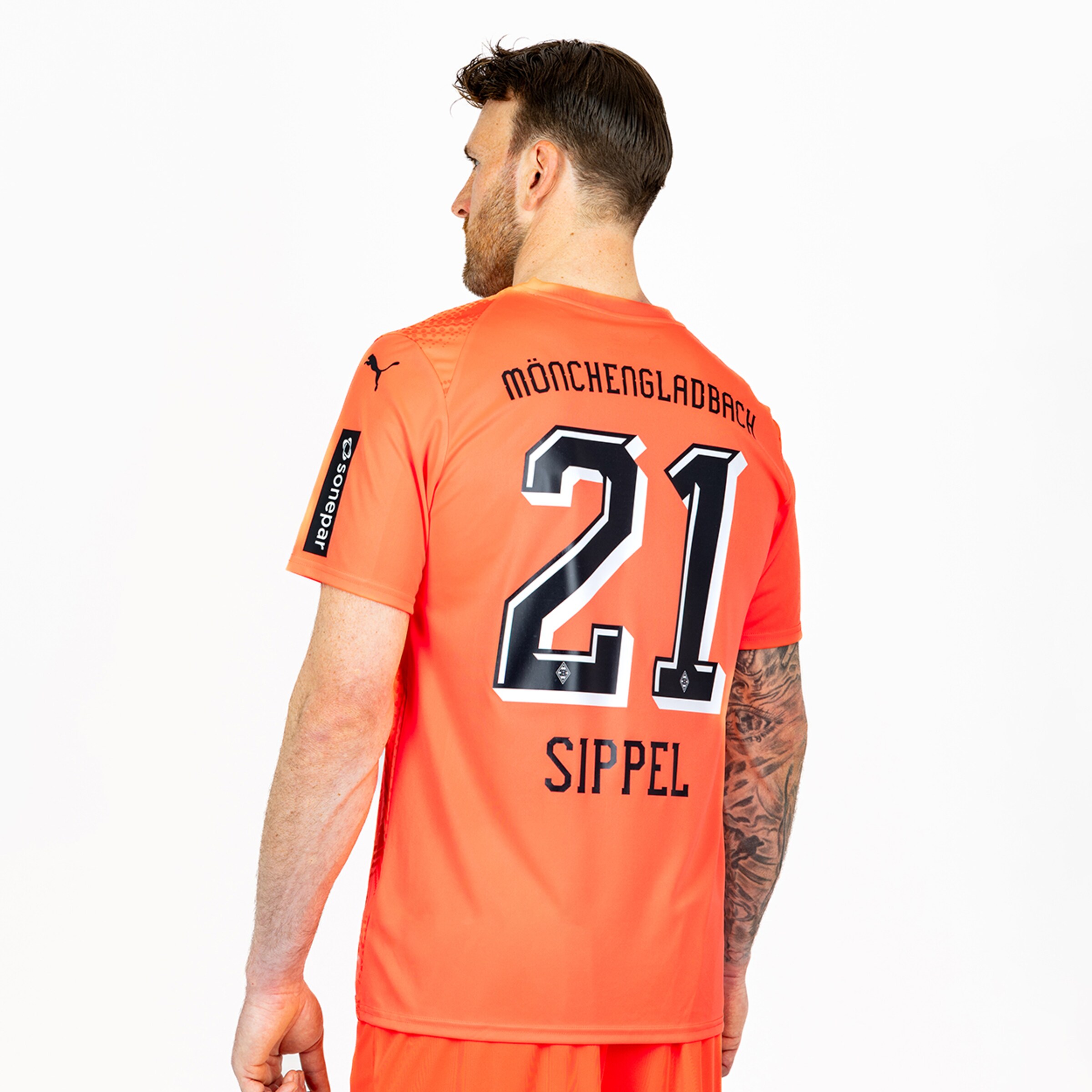 Rear view of a man in an orange soccer jersey with MÖNCHENGLADBACH, number 21, and the name SIPPEL printed on the back.