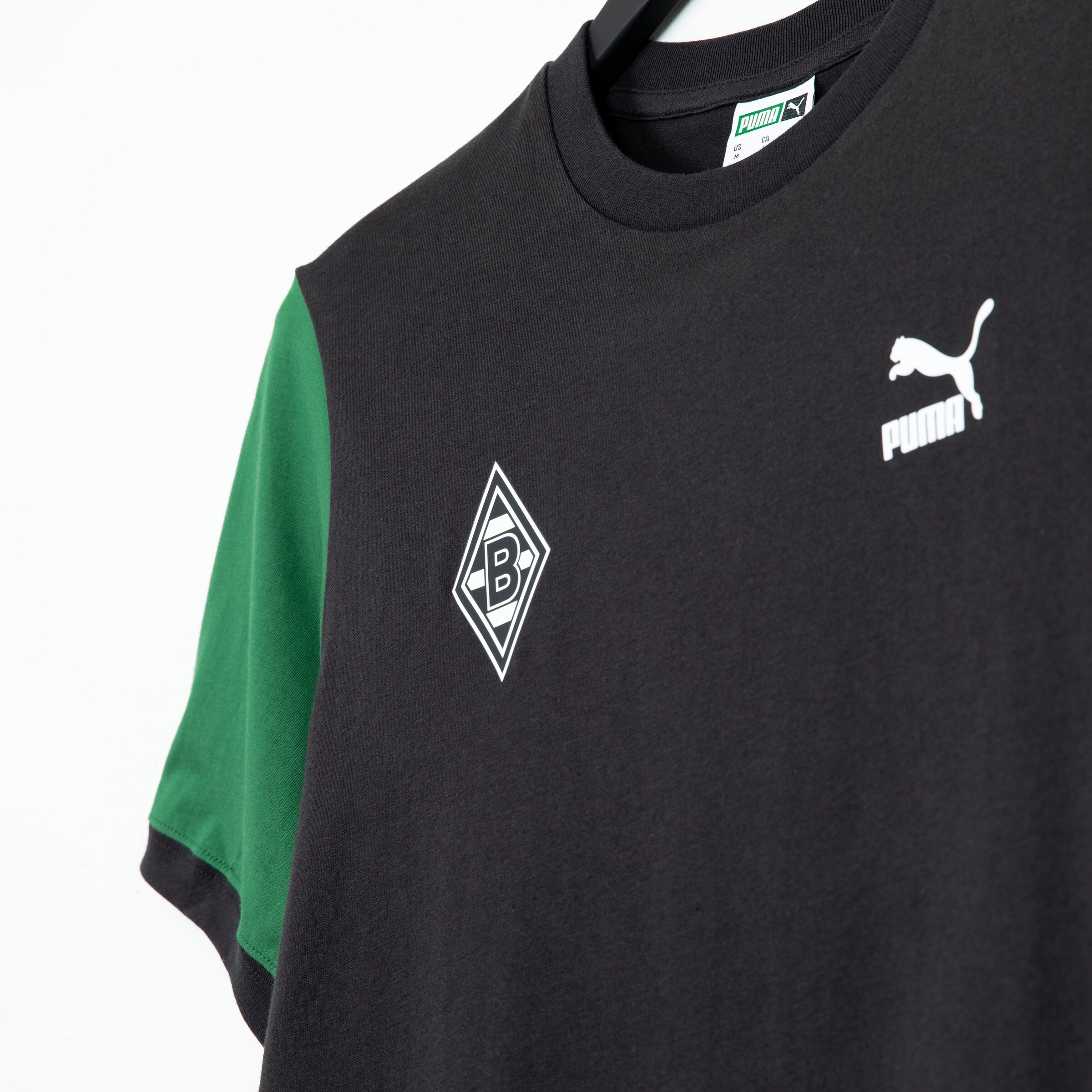 Black soccer jersey of Borussia Mönchengladbach with green sleeves and Puma logo.
