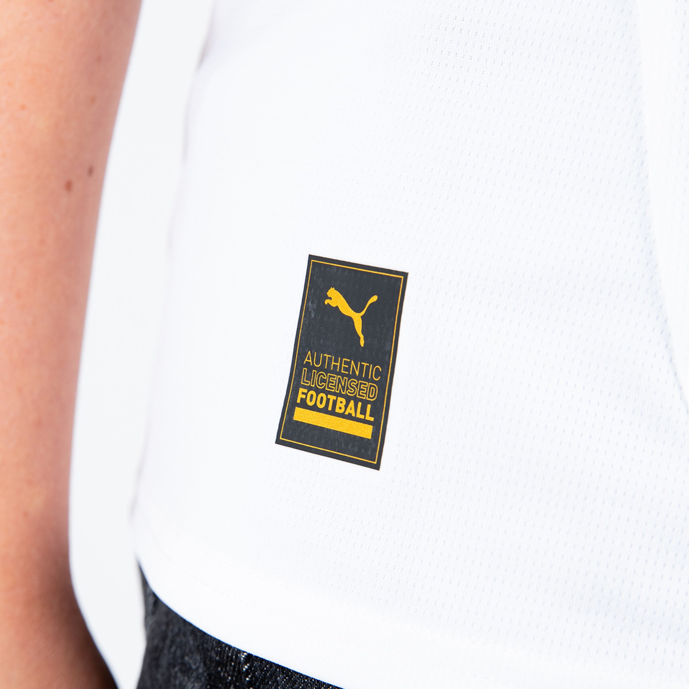PUMA-Logo und Lizenzsiegel auf einem weißen Fußballtrikot.
