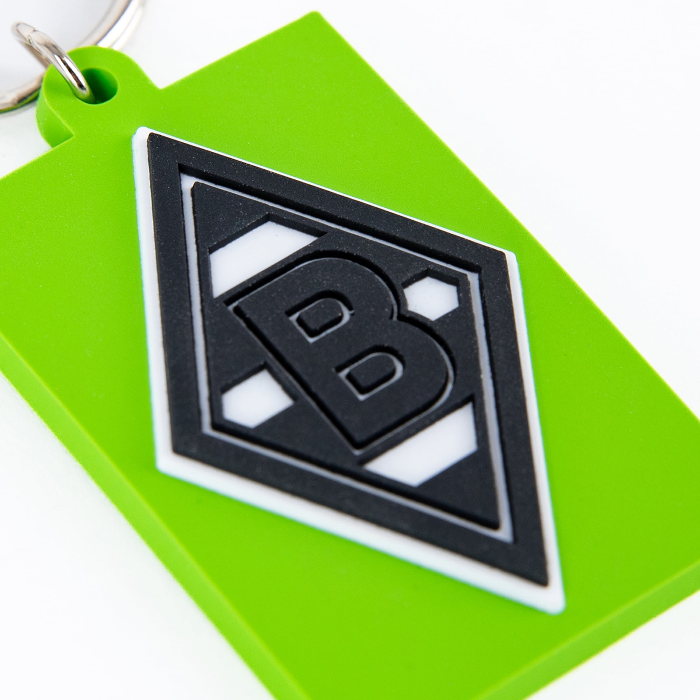 Schlüsselanhänger mit dem Borussia Mönchengladbach Logo auf grünem Hintergrund.