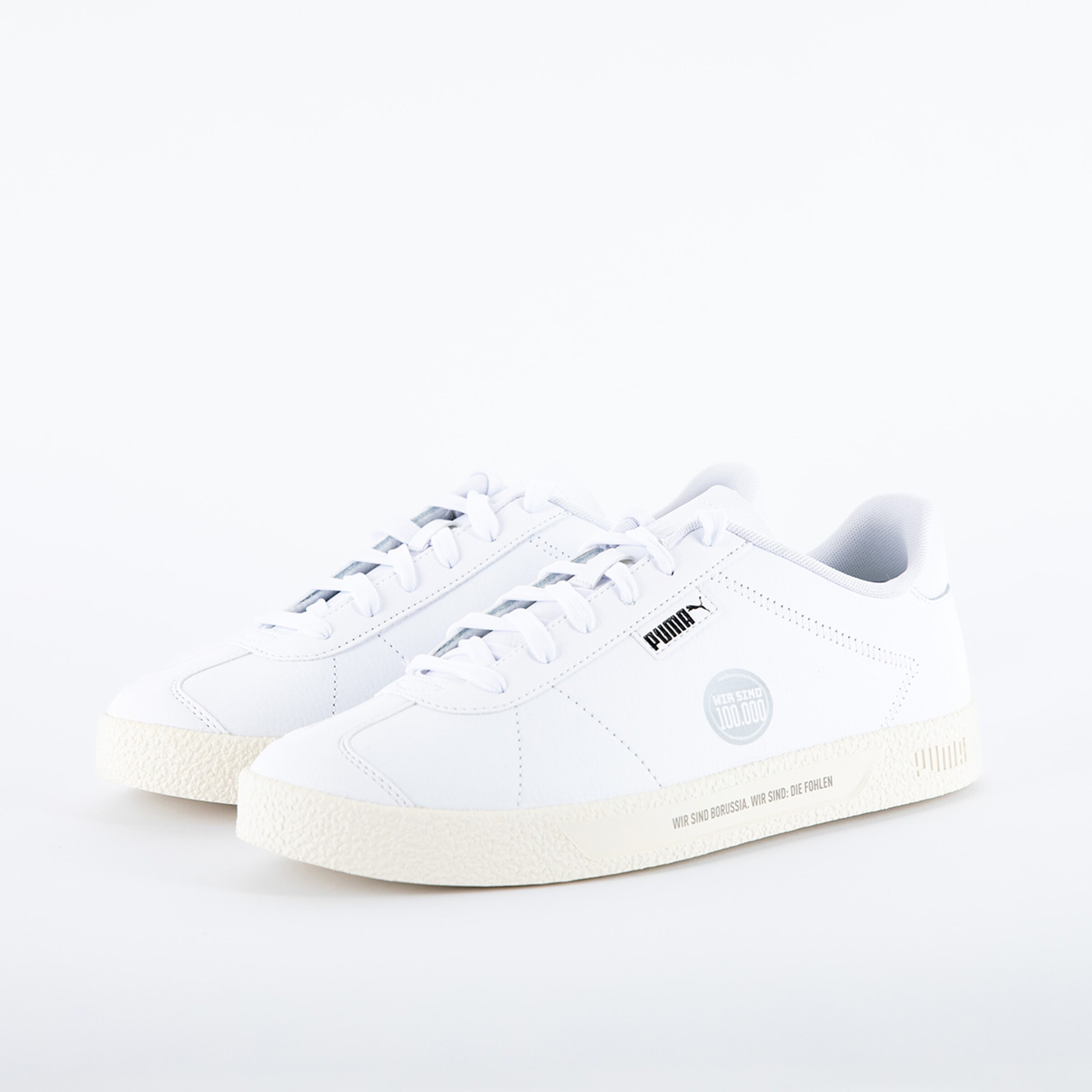 Weiße PUMA Sneaker mit flacher Sohle und Schnürung.