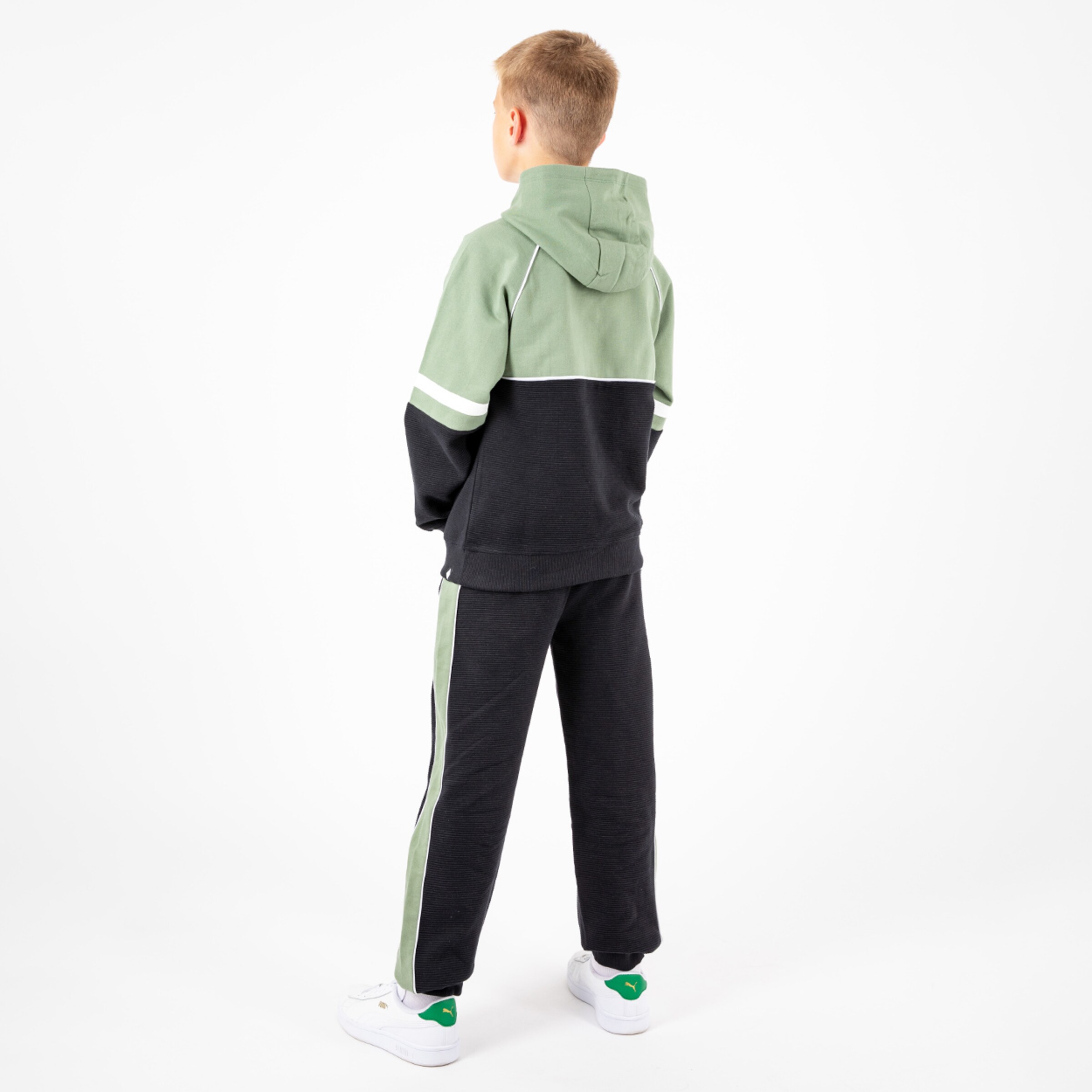 Junge in lässigem Sportanzug mit Kapuze Rückenansicht.