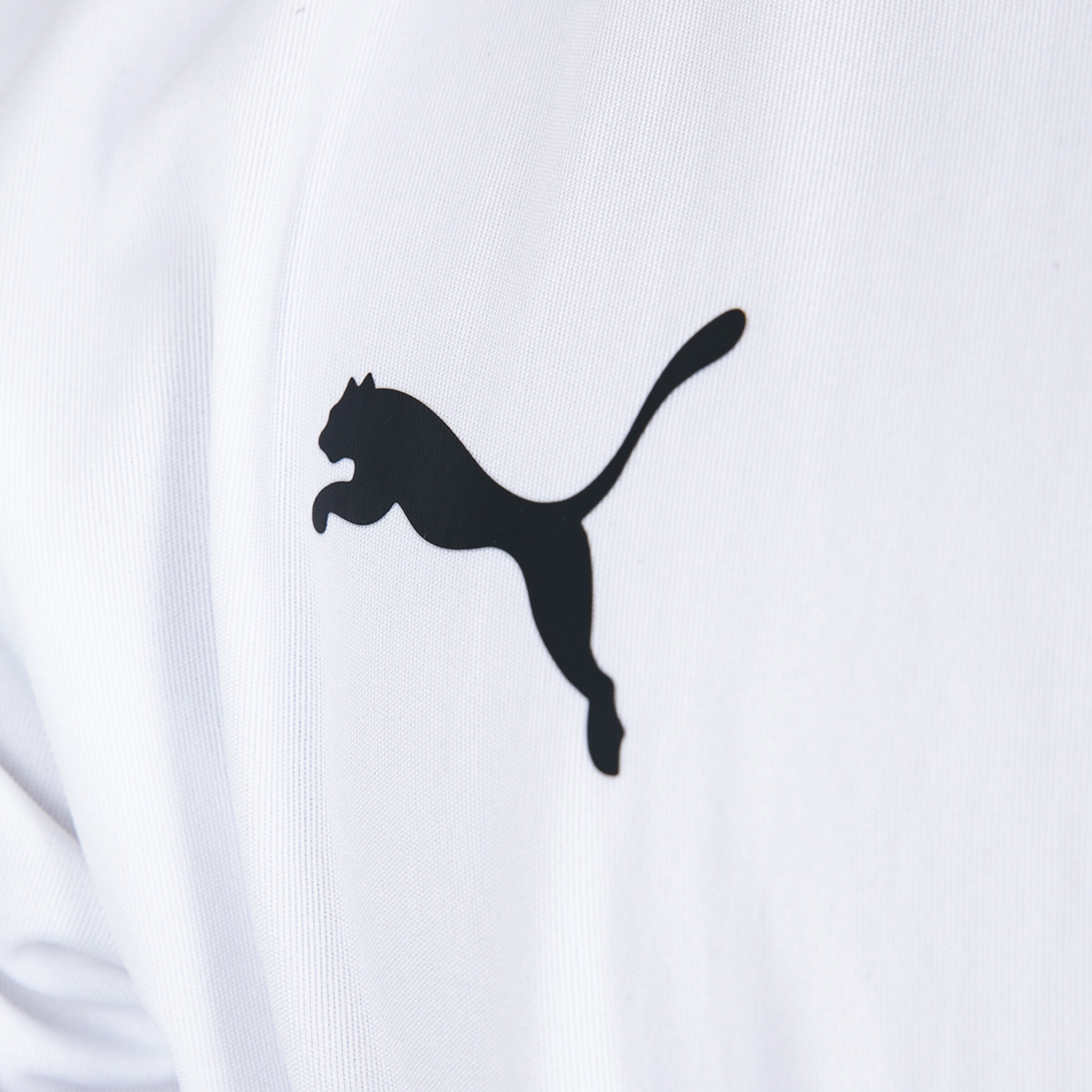 Black Puma logo on white fabric.