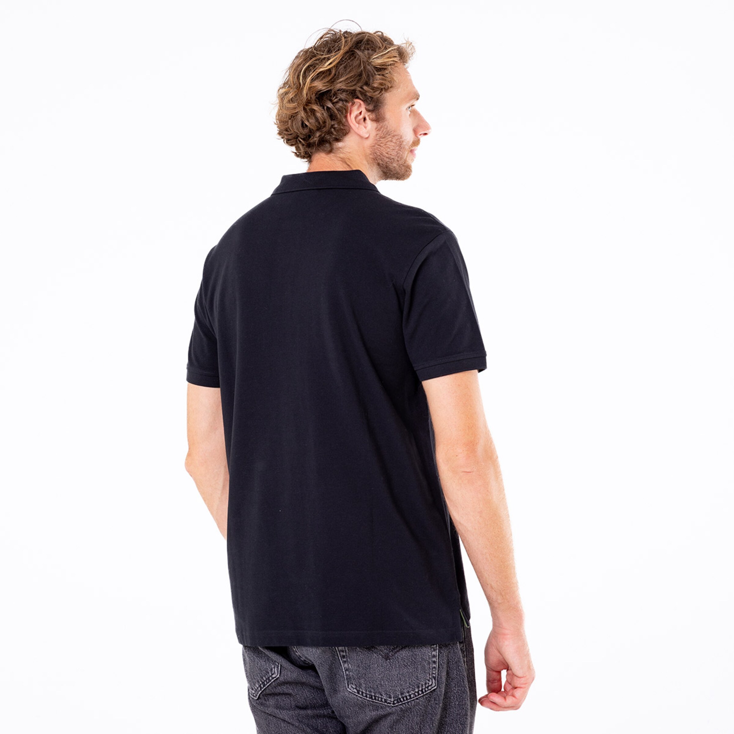 Mann von hinten in einem schwarzen Poloshirt.