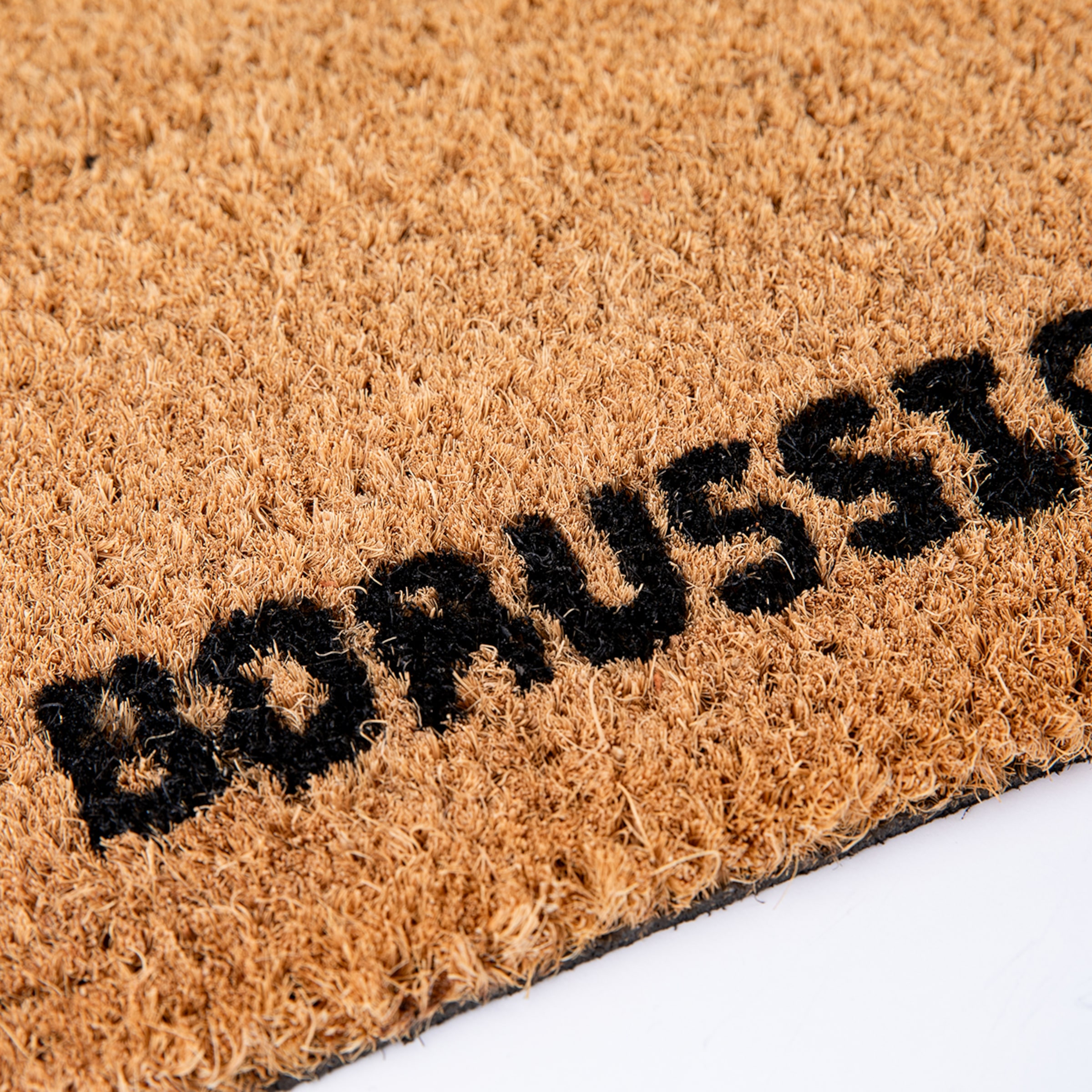 Nahaufnahme einer natürlichen braunen Kokos-Fußmatte mit dem schwarzen Schriftzug 'BORUSSIA', schräg auf weißem Untergrund. Die Faserstruktur ist deutlich sichtbar.