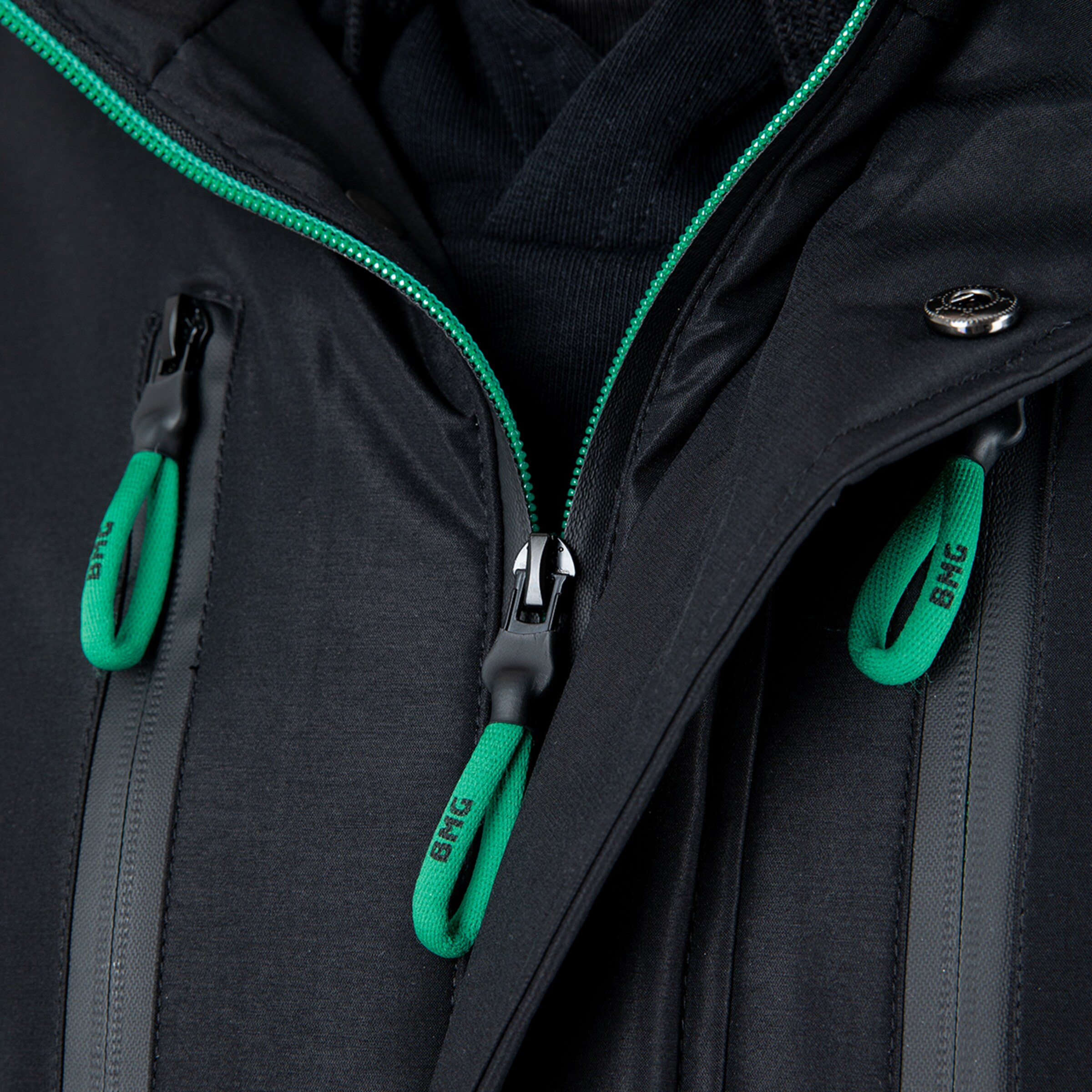 Detailaufnahme eines schwarzen Parka mit grünem Reißverschluss und Zipperpulls von Borussia Mönchengladbach.