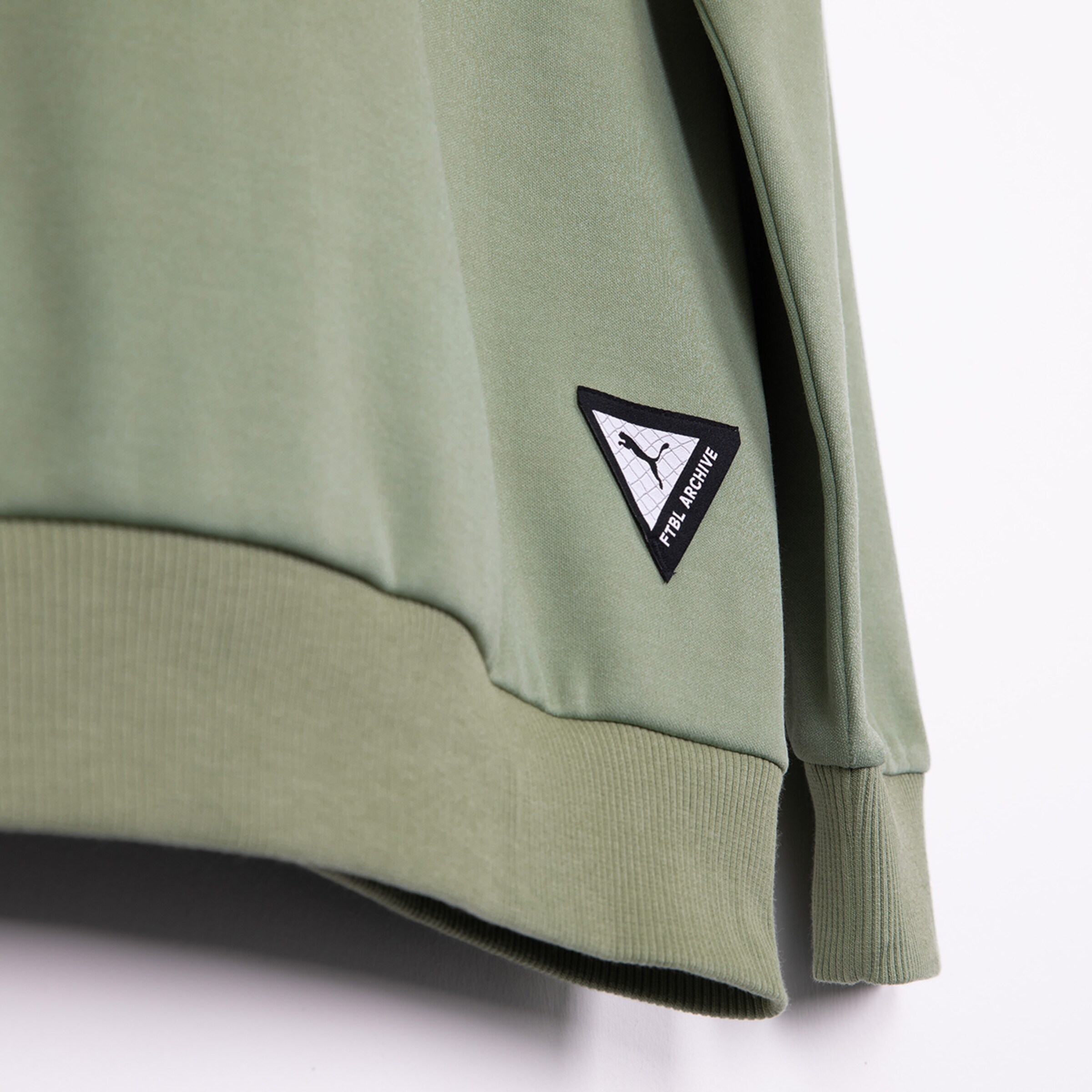 Grüner Sweatshirt mit schwarzen Details und Patches.