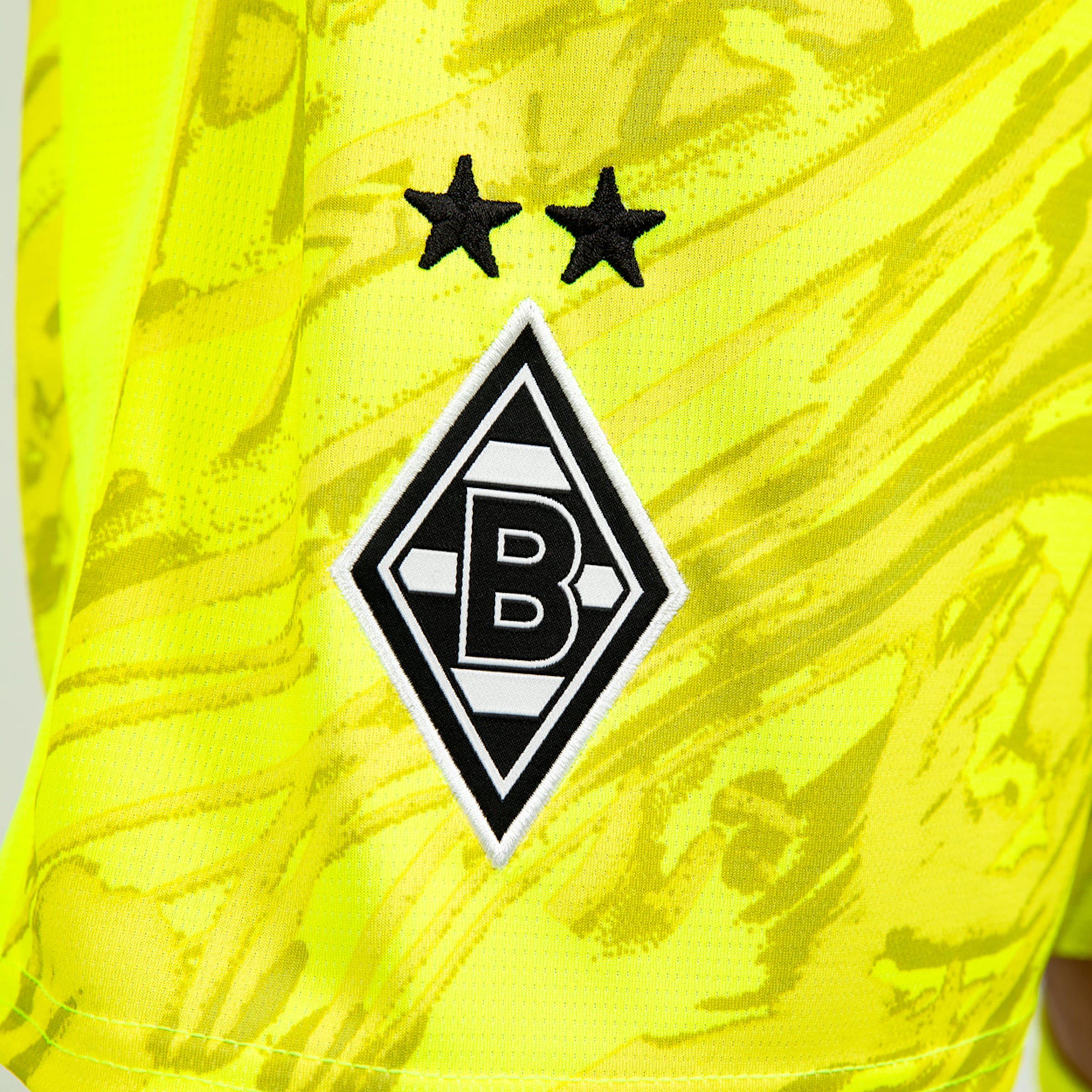 Borussia Mönchengladbach logo with two stars on a yellow jersey.