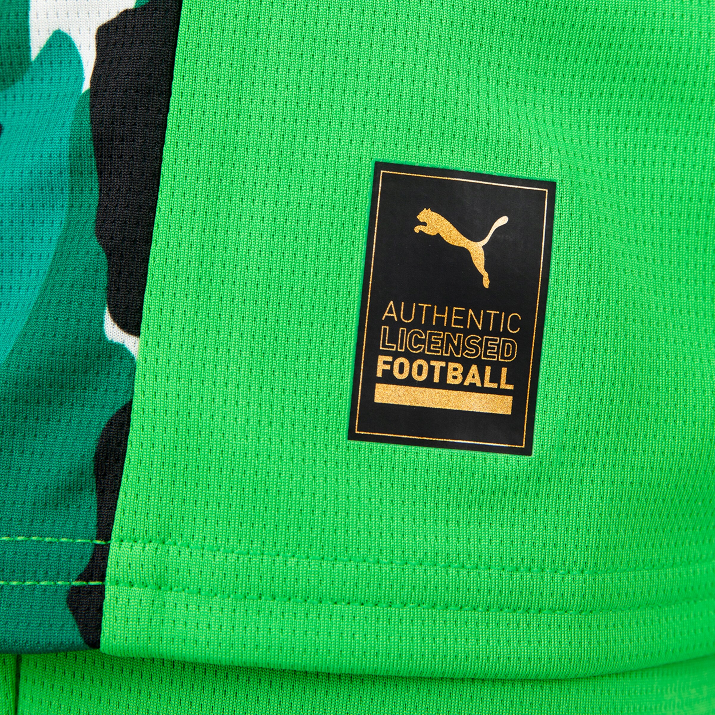 Authentisches Lizenzlogo für Fußball von Puma auf einem grünen Trikot.