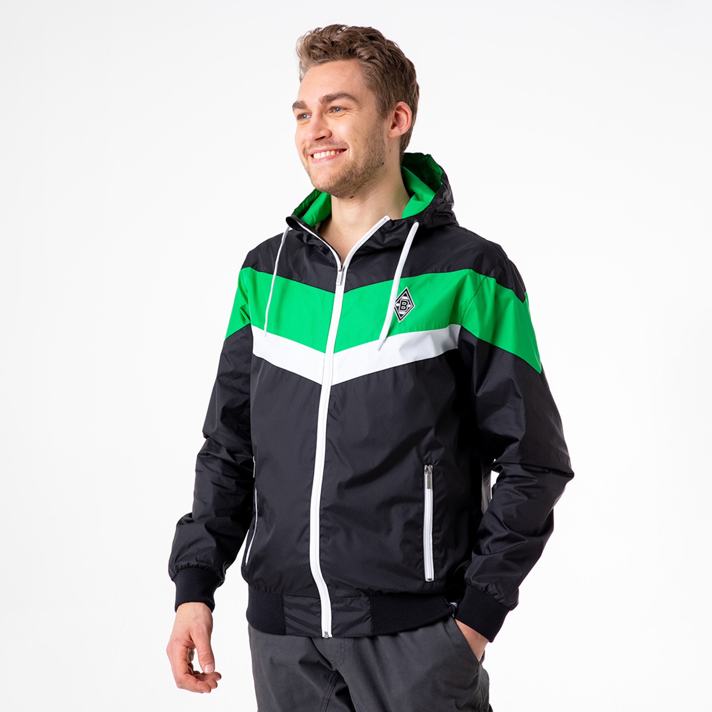 Mann in schwarzer Jacke mit grünen und weißen Streifen