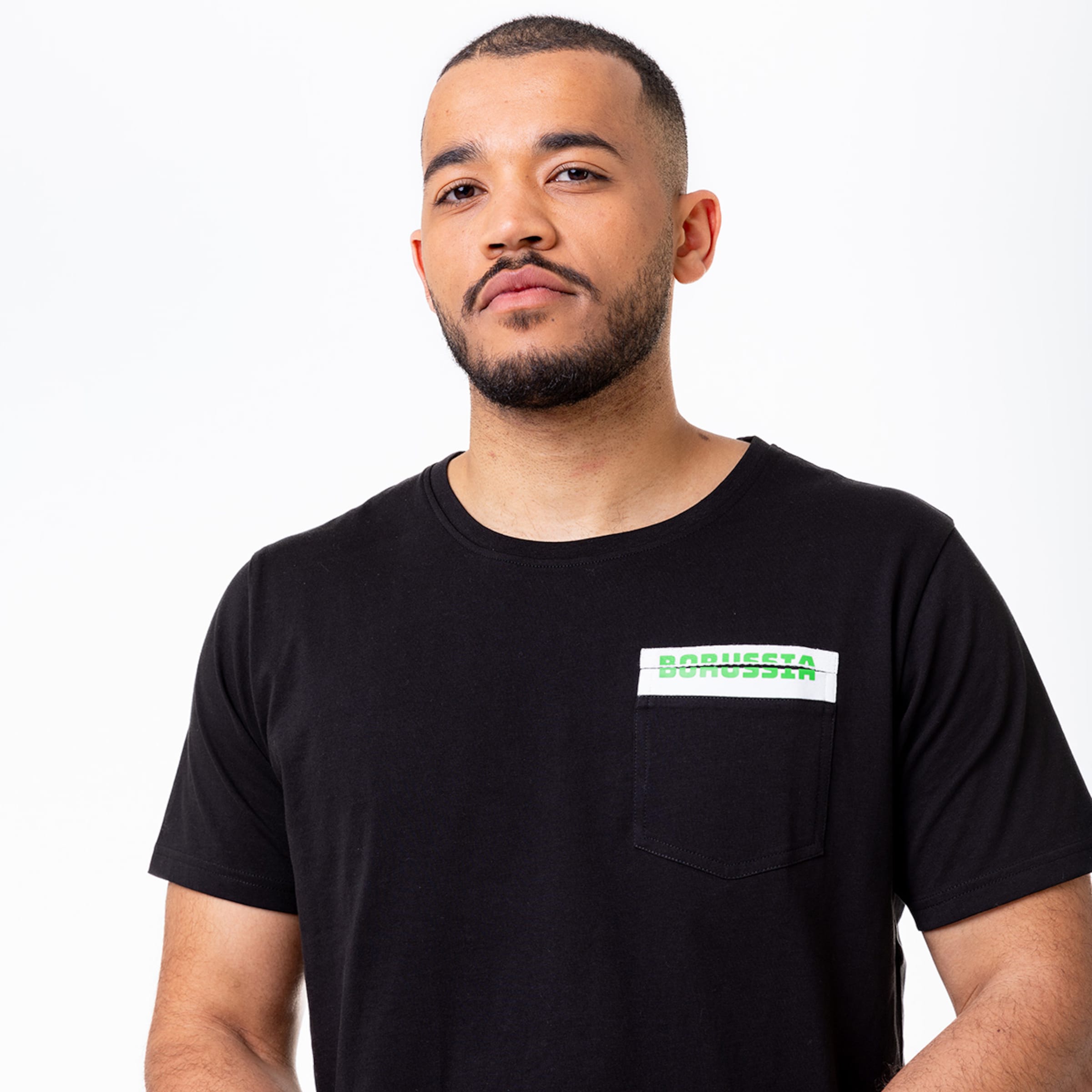 Mann mit Bart trägt schwarzes T-Shirt mit einer Brusttasche und dem Text Borussia Mönchengladbach