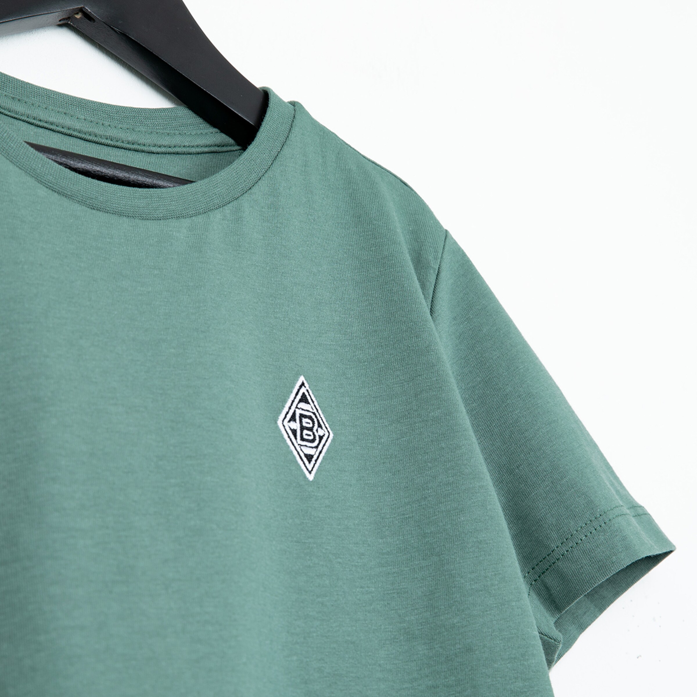 Grünes T-Shirt mit Borussia Mönchengladbach-Logo auf der linken Brustseite.