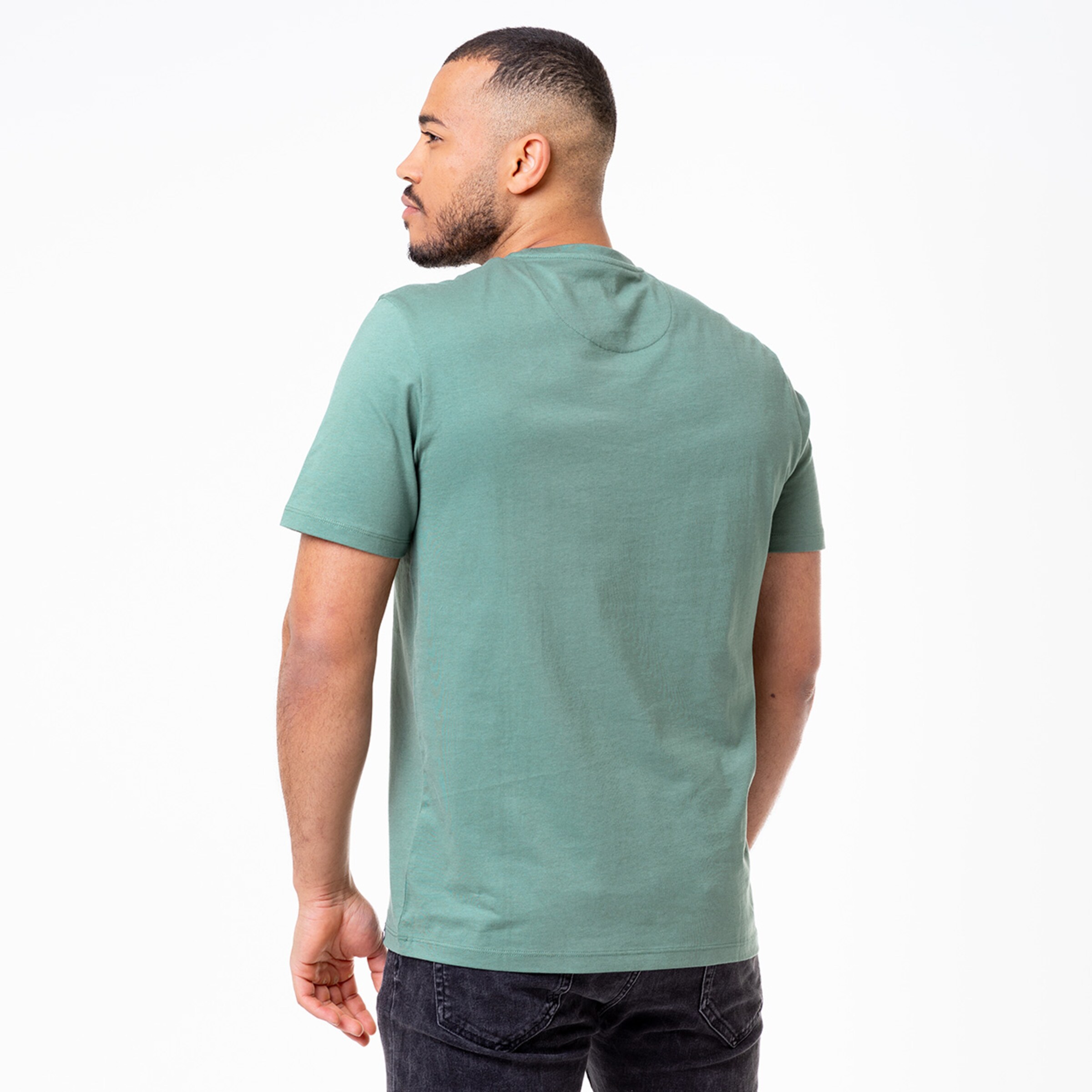Man seen from behind wearing a green t-shirt looking to the side.