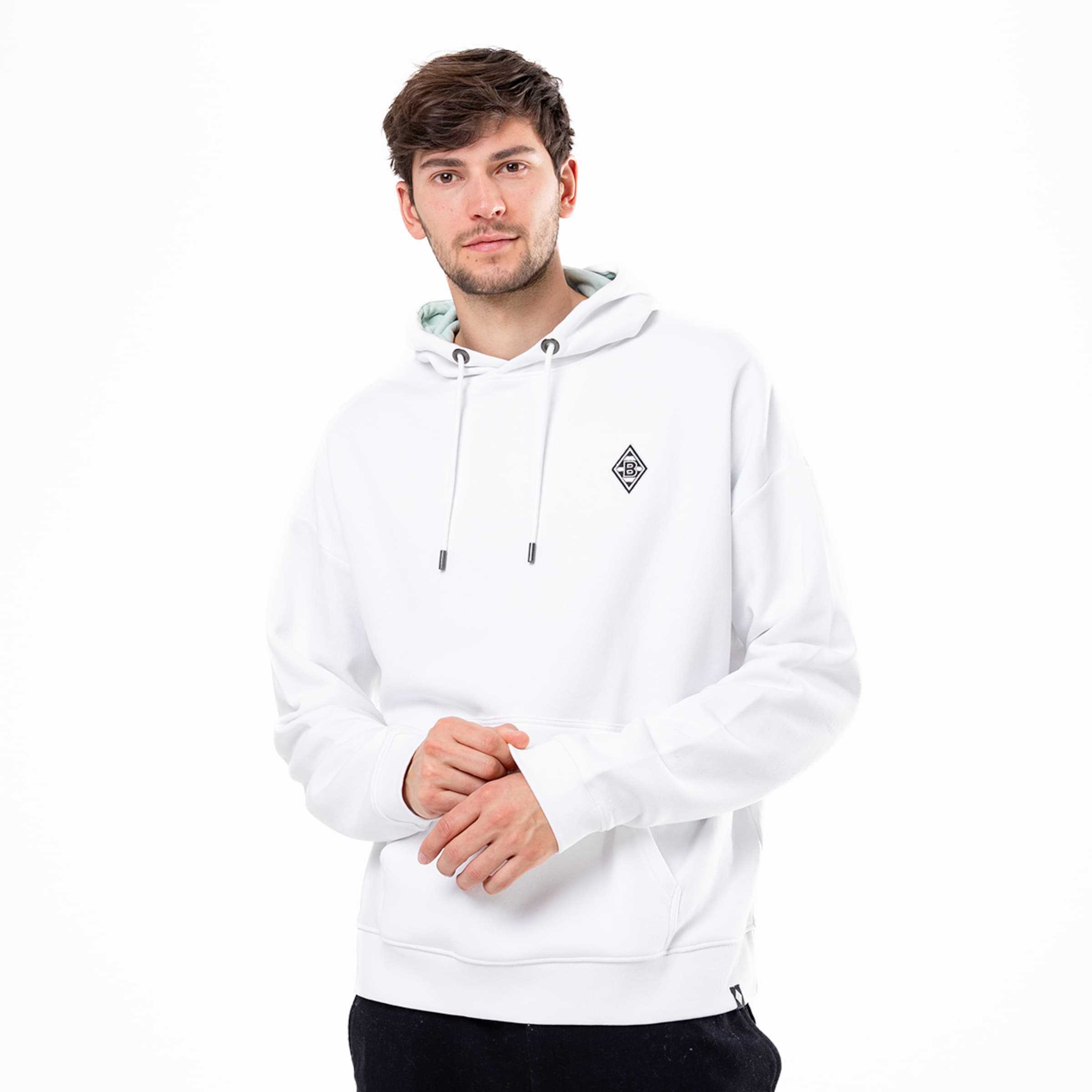 Mann trägt einen weißen Kapuzenpullover mit Logo auf der Brust.