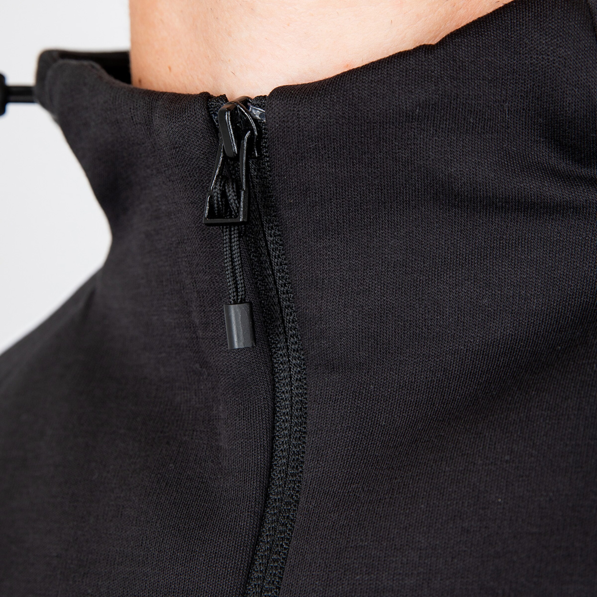 Nahaufnahme eines halbgeschlossenen schwarzen Oberteils mit Reißverschluss.