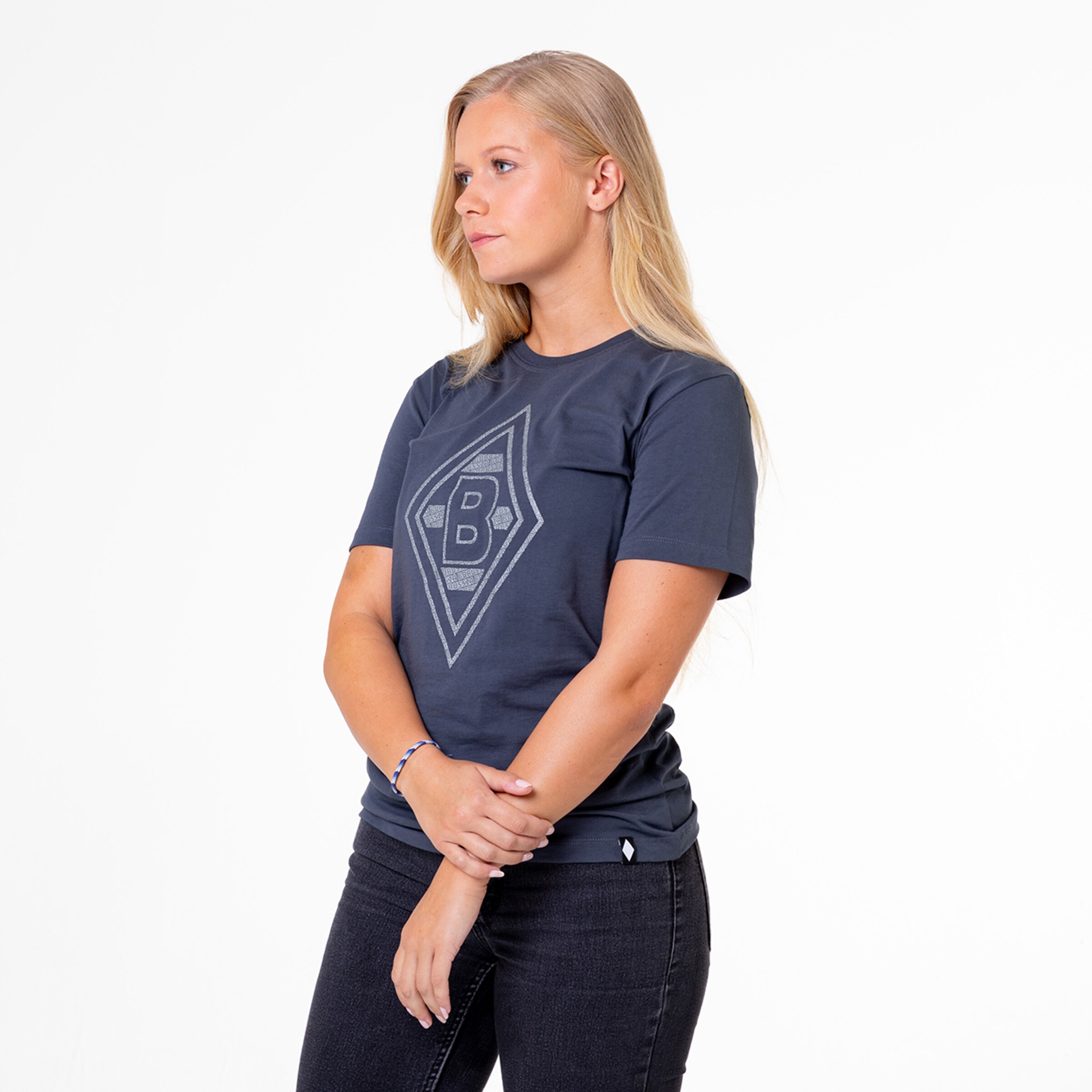 Junge Frau trägt ein dunkelblaues T-Shirt mit dem Borussia Mönchengladbach-Logo.