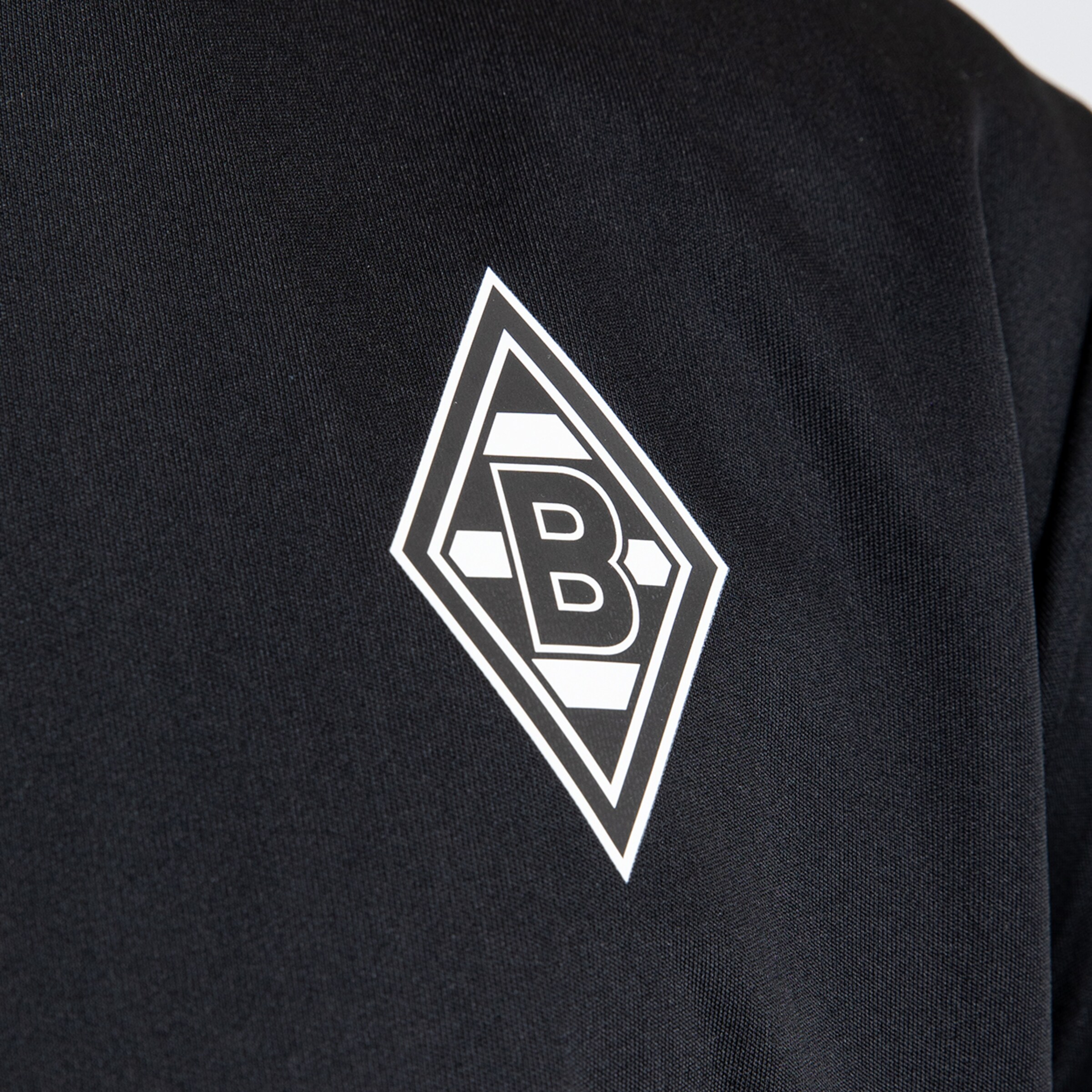 Logo of Borussia Mönchengladbach on a black jersey.