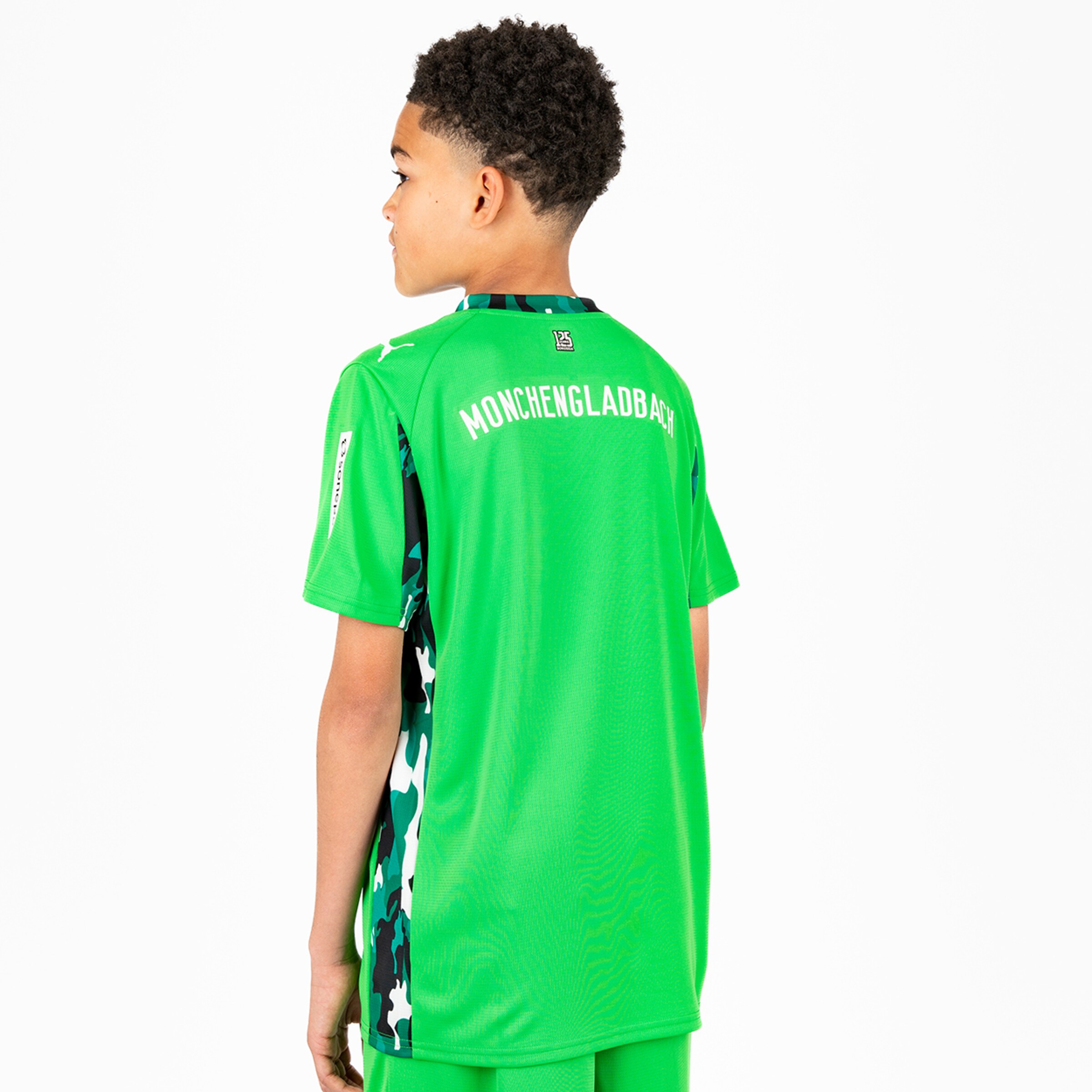 Junge trägt das grüne Torwarttrikot von Borussia Mönchengladbach.