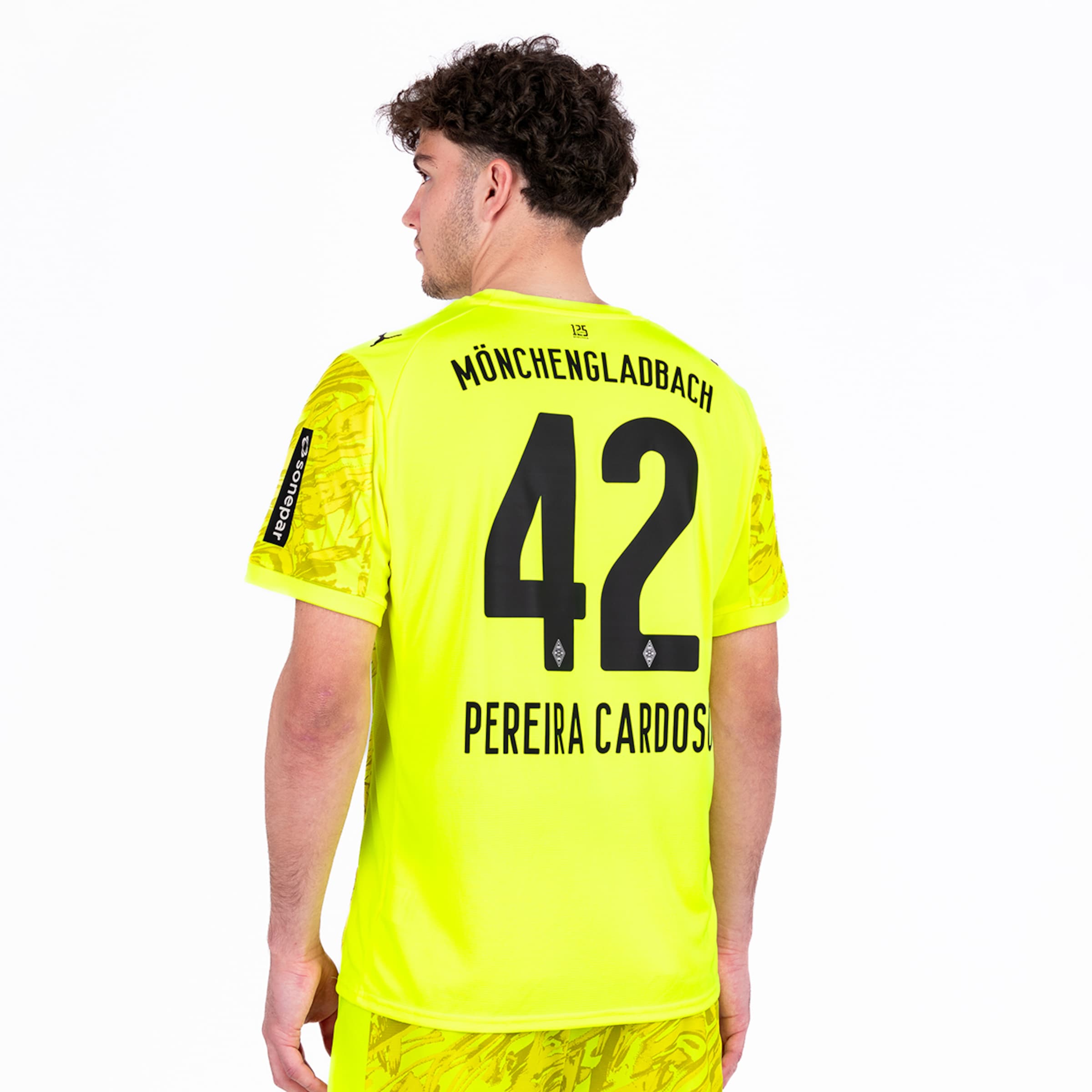 Soccer player wearing a bright yellow jersey with number 42 and name Pereira Cardoso of Borussia Mönchengladbach.
