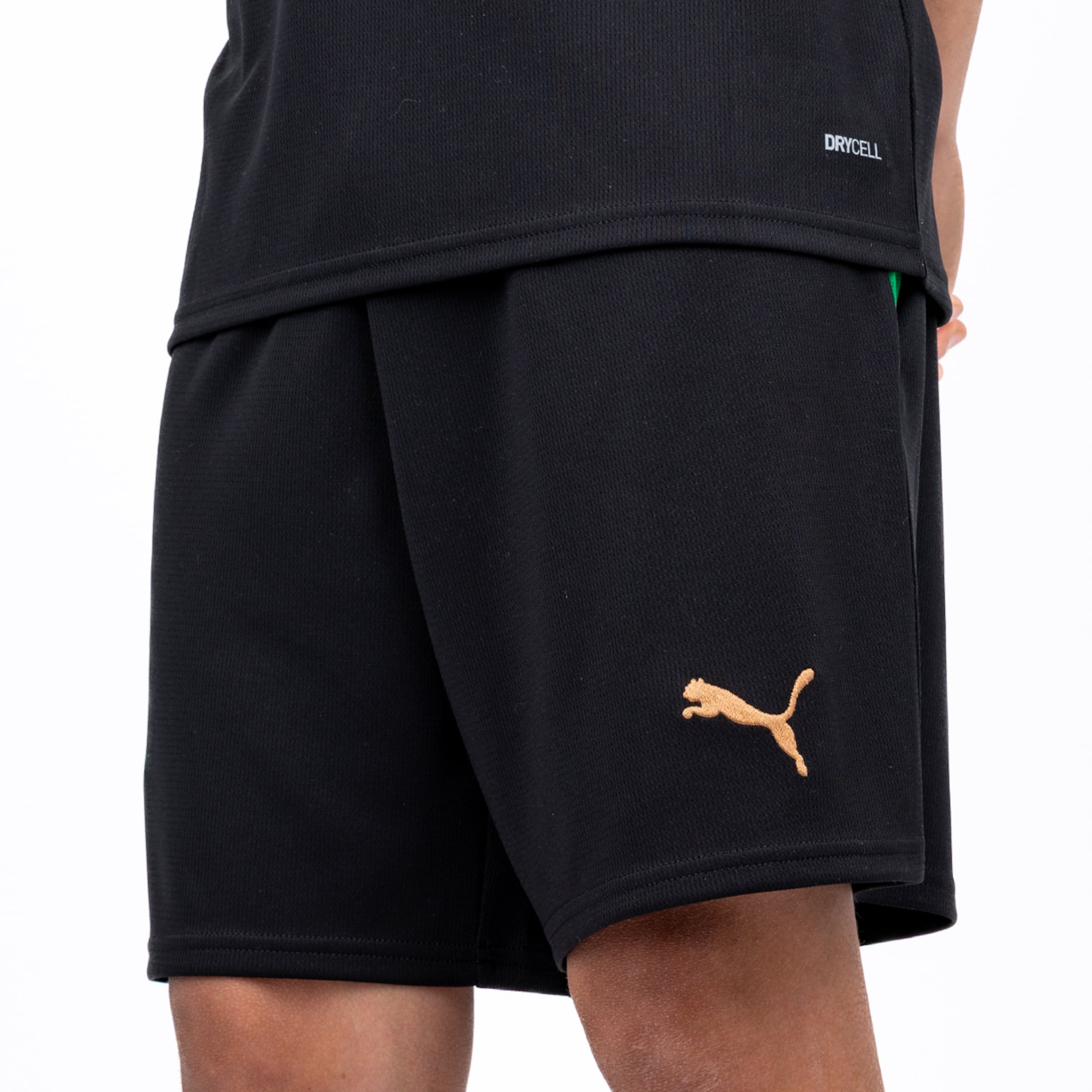 Schwarze Puma-Sportshorts mit goldenem Logo und DRYCELL-Funktionsshirt vor weißem Hintergrund.