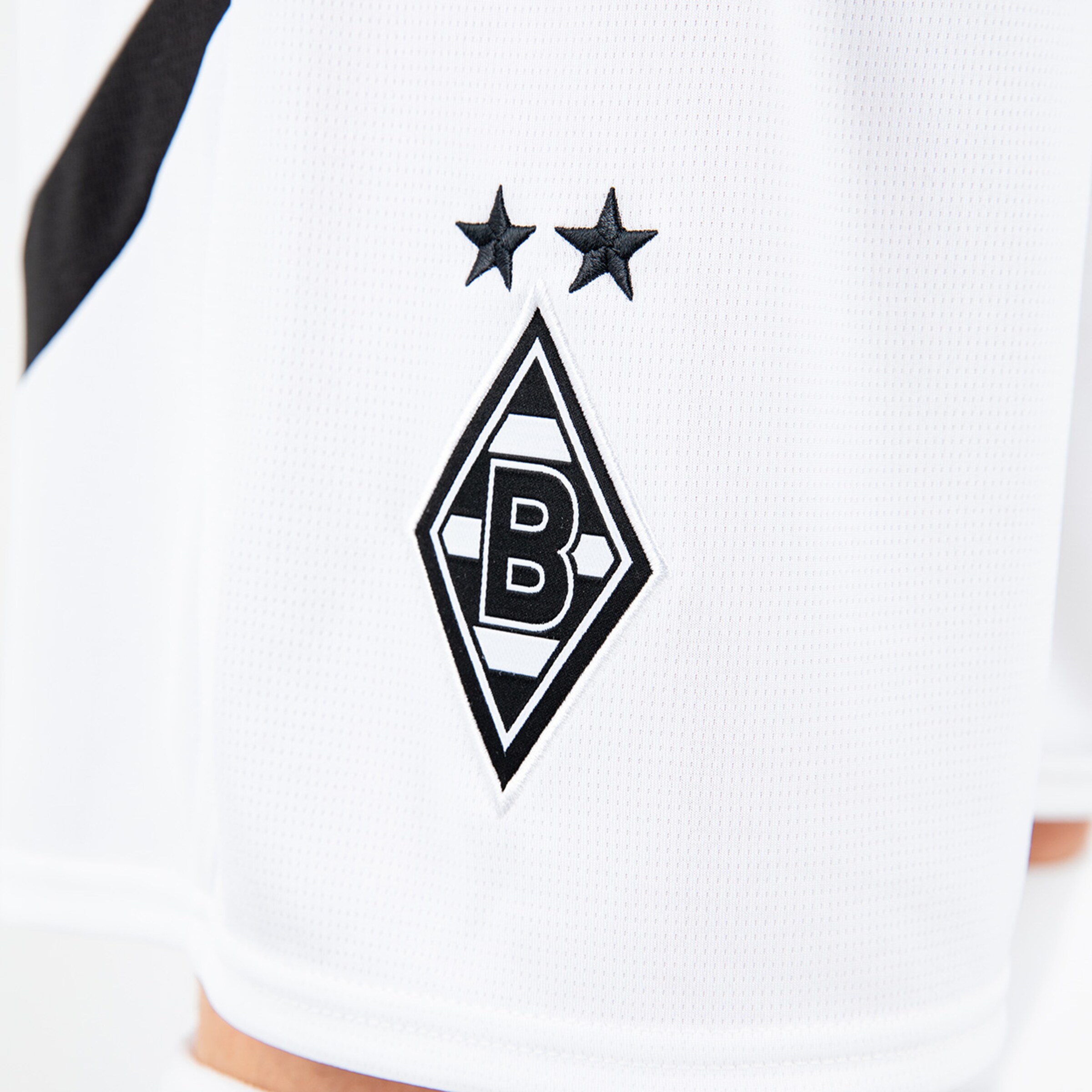Logo von Borussia Mönchengladbach auf einem weißen Trikot mit zwei Sternen.