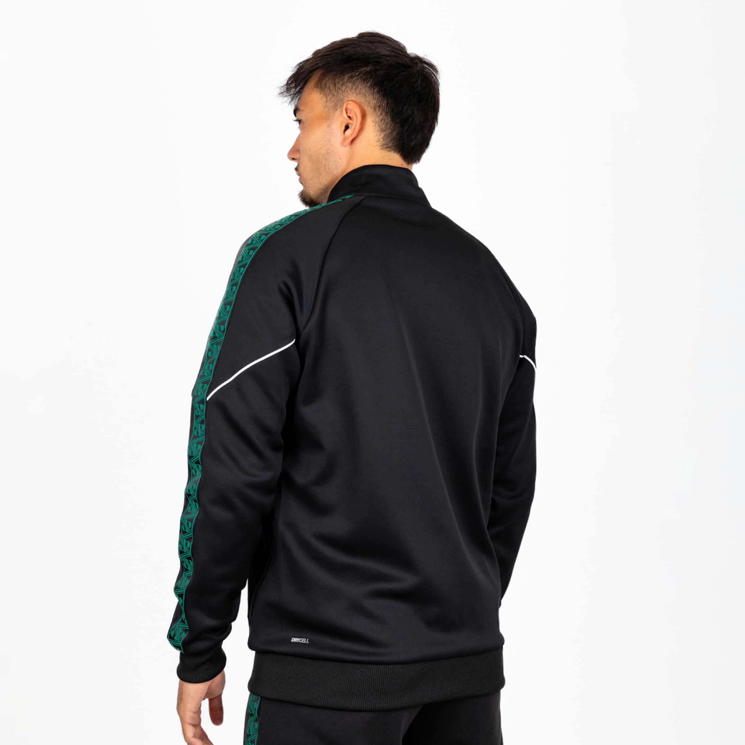 Rückansicht eines Mannes in schwarzer Trainingsjacke mit grün gemusterten Ärmelstreifen und weißen Akzenten.