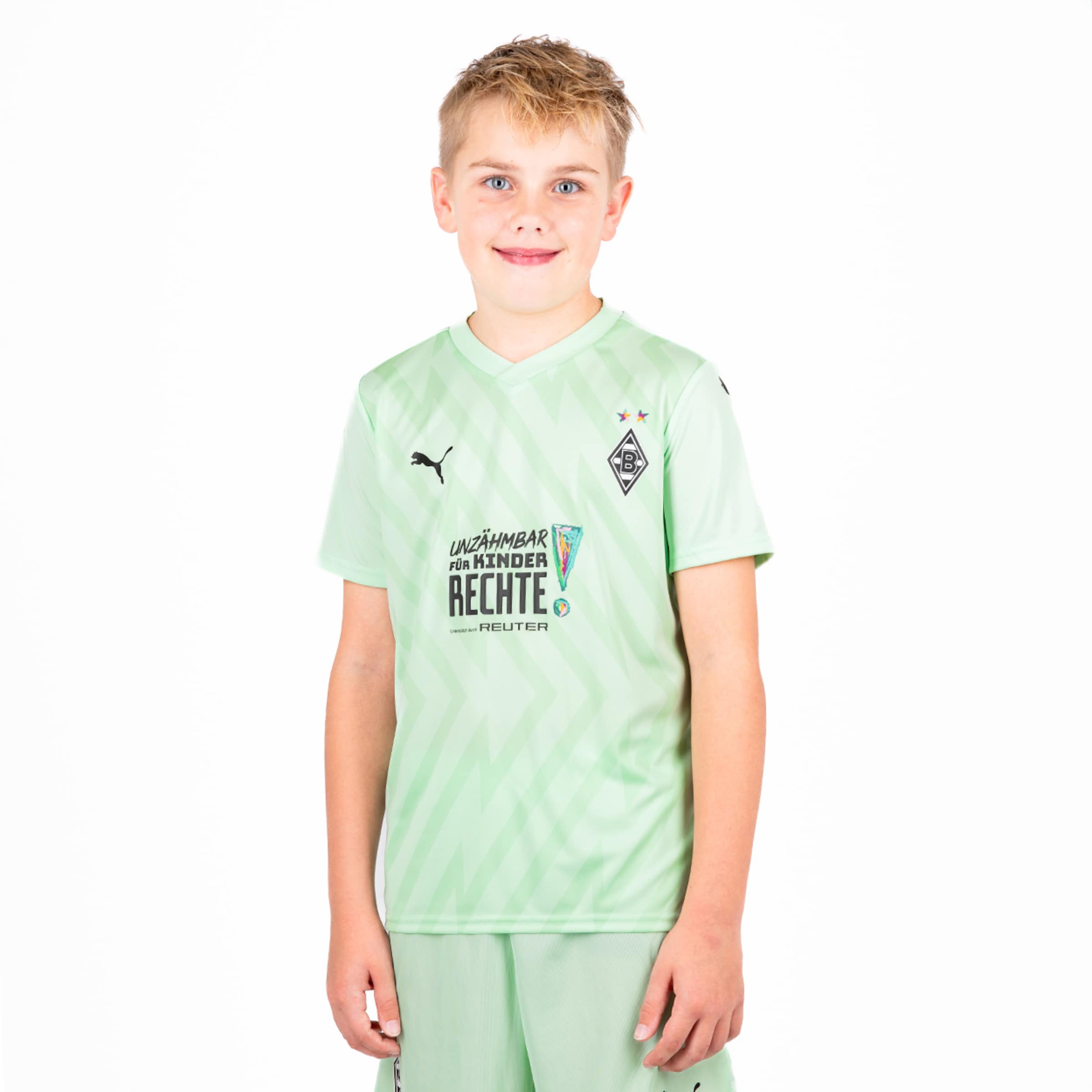 Ein Junge trägt das grüne Trikot von Borussia Mönchengladbach.