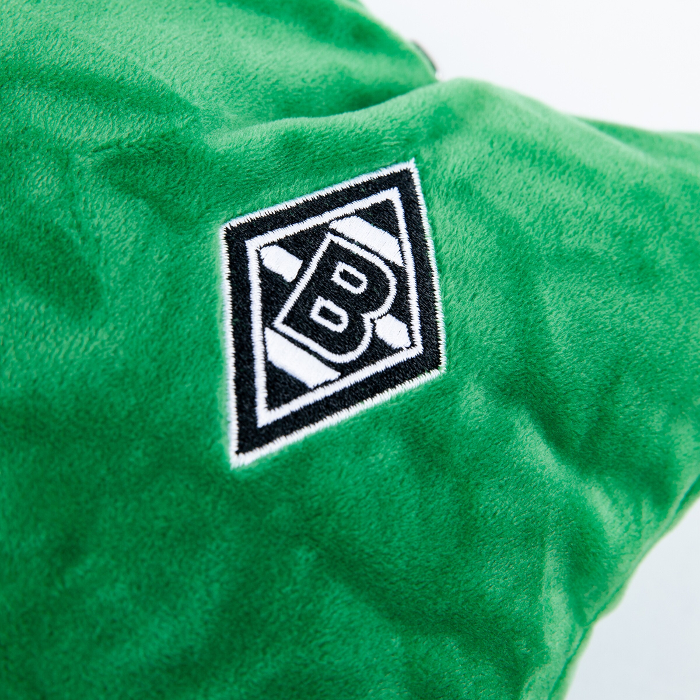 Green pillow with embroidered Borussia Mönchengladbach logo.